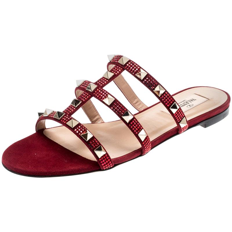 These Valentino slides feature a stunning scarlet suede body that comes with straps on the top and detailed with the signature Rockstuds. Easy to slide it on and off, these pair makes a great accompaniment to dresses and skirts alike. Style with a
