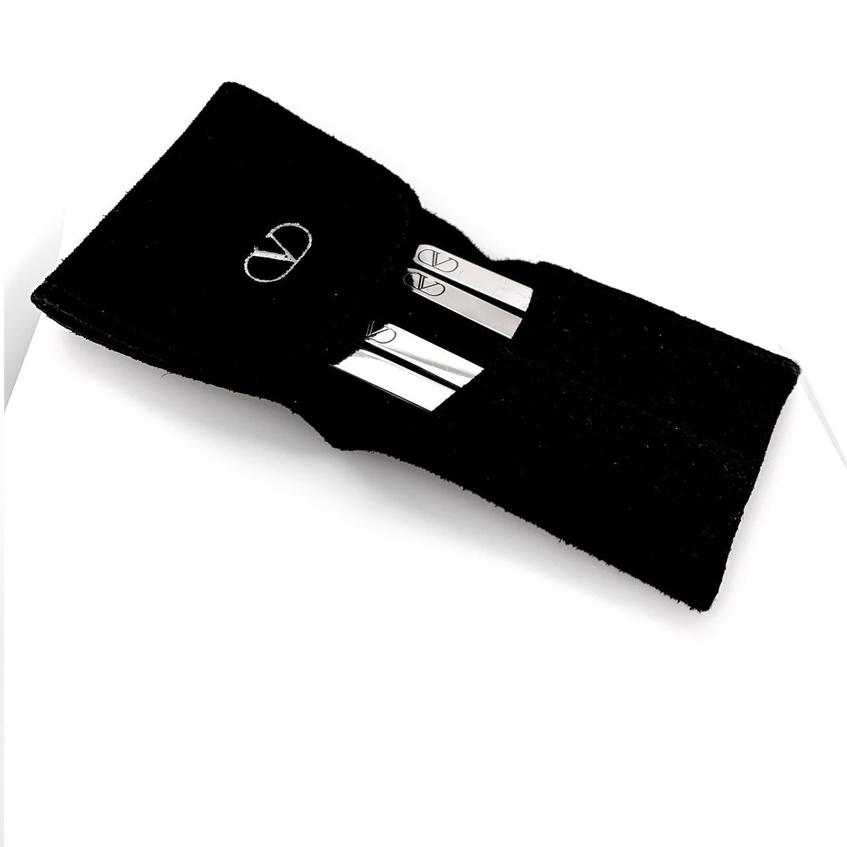 For the well-appointed gentleman:  a set of four sterling silver collar stays.  Made by VALENTINO and stamped with the Valentino maker's mark.   In original black suede fold-over pouch with embossed logo.  2.35