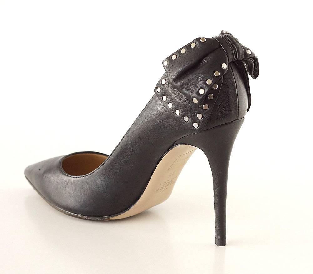 Guaranteed authentic Valentino black leather pump.
Black leather pump with stunning studded bow.
Signature leather bow is richly tied and folded against the heel.
Flat silver toned studs around bow.
Pointed toe and with sexy heel.
An elegant day or