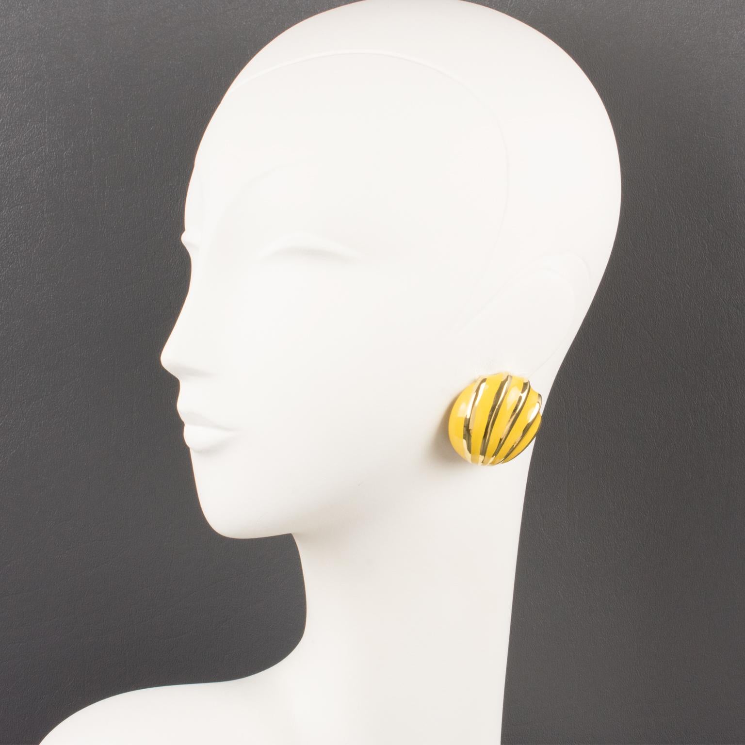 Lovely Valentino Garavani couture clip-on earrings. Dimensional rounded shape with shiny gilt metal contrasted with yellow enamel in a seashell striped design. Valentino hallmark underside.
Measurements: 1.44 in. diameter (3.7 cm).