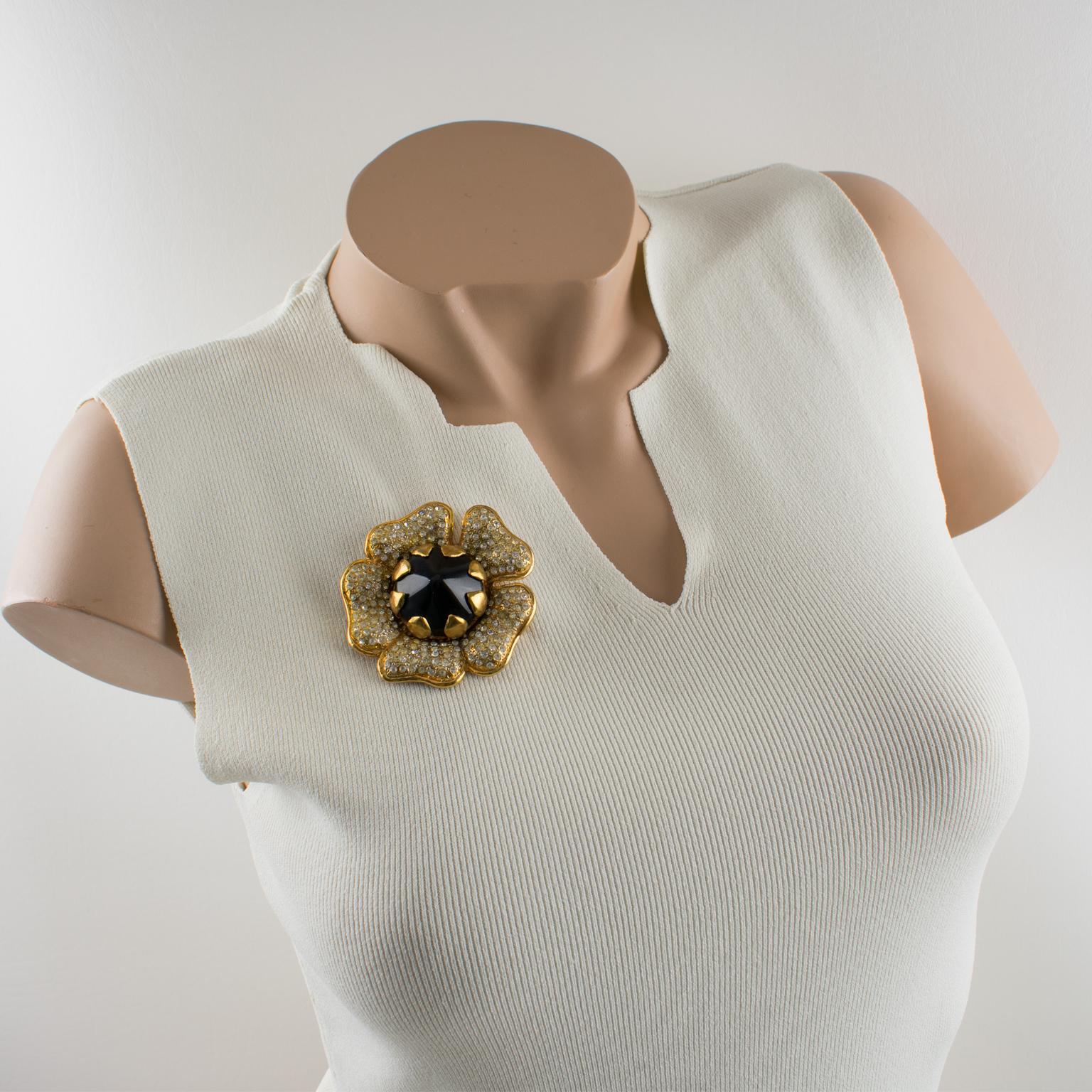 Lovely Valentino Garavani couture pin brooch. Huge dimensional gilt metal flower shape all paved with tiny crystal clear rhinestones and topped with black resin cabochon heart. Security closing clasp. Valentino hallmark underside.
Measurements: 2.75