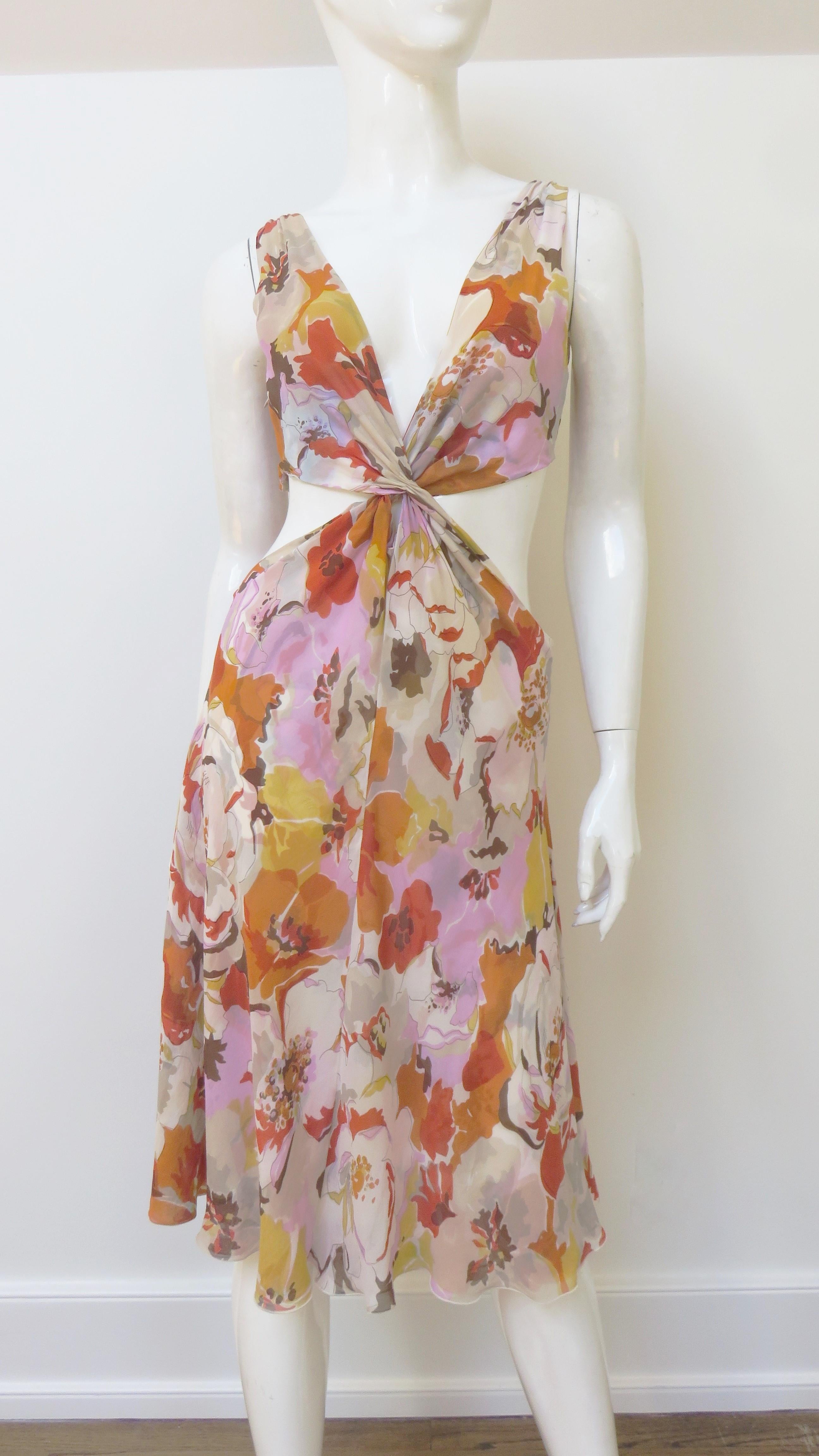 A gorgeous flower print silk dress from Valentino in pink, orange, off white, gold and brown.  It is sleeveless with a plunging neckline front and back, cut outs at the waist and a full skirt.  It is lined in same fabric and has a side zipper.
Fits