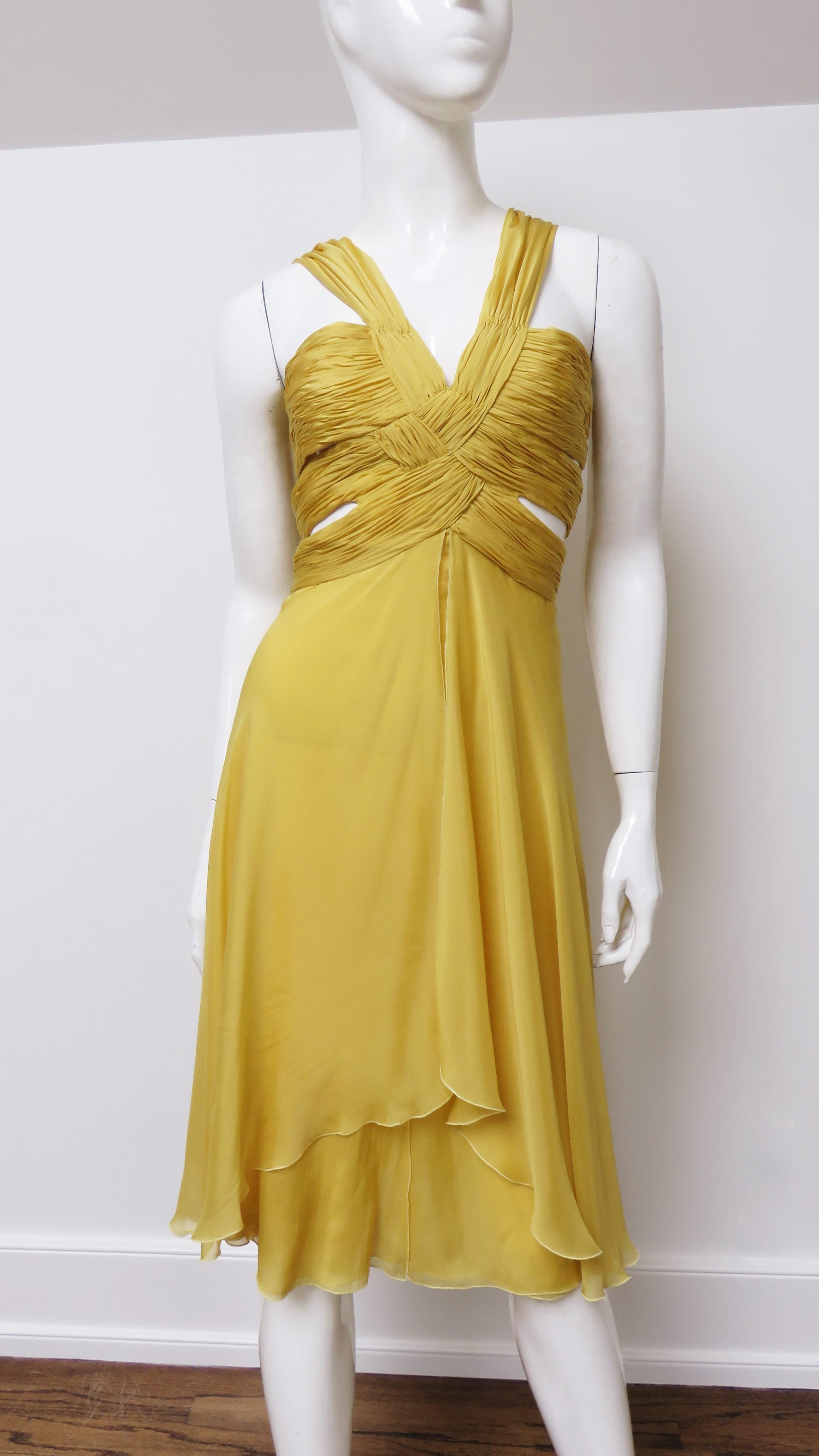 A gorgeous marigold yellow fine silk dress from Valentino.  It has ruched shoulder straps forming a V neckline and 3 bands of horizontal ruching around the circumference of the bodice which expose wedges of skin in between them at each side waist.