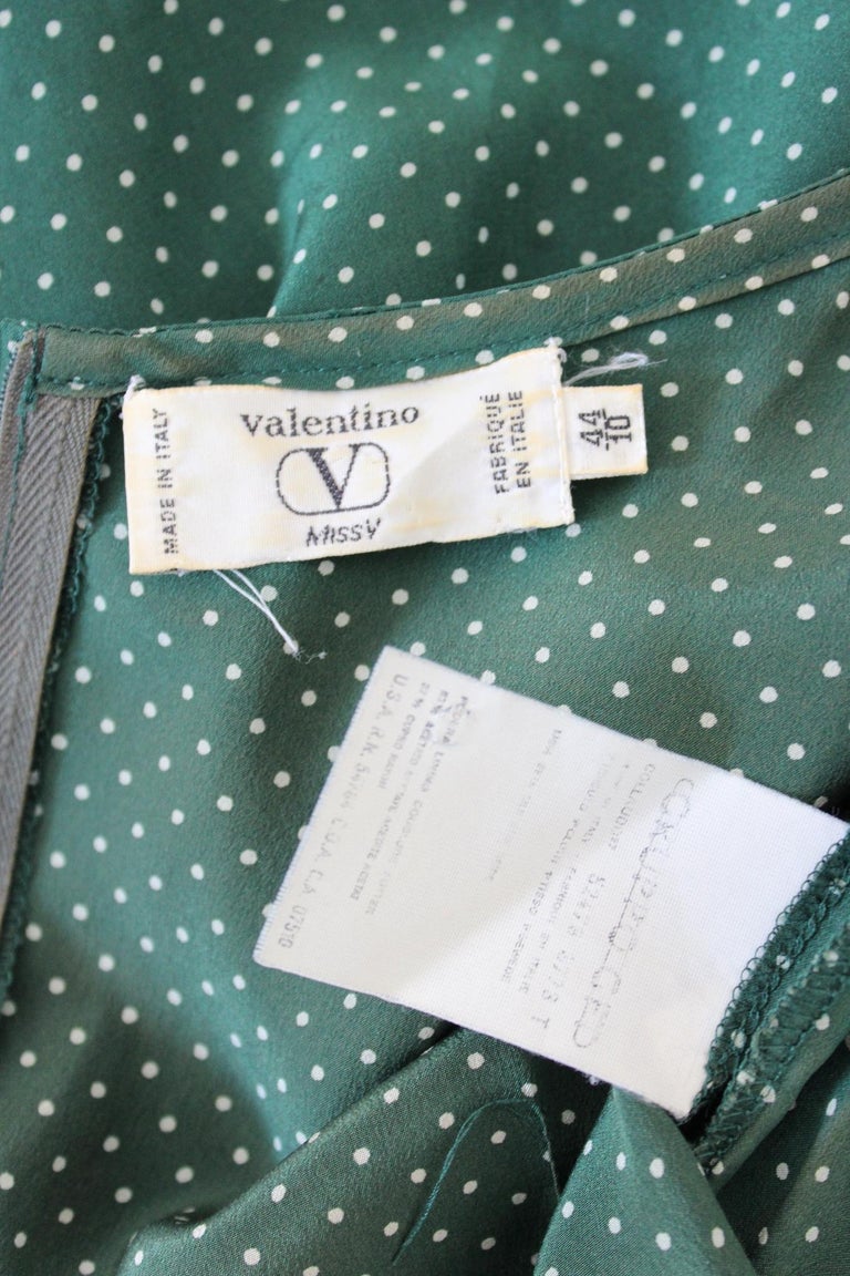 Valentino vintage 90s silk party dress. Green color with white polka dots, short sleeve. The front of the dress opens like a wrap towards the right. This particular shape gives movement to the dress. Made in Italy. Add it to your wardrobe for a