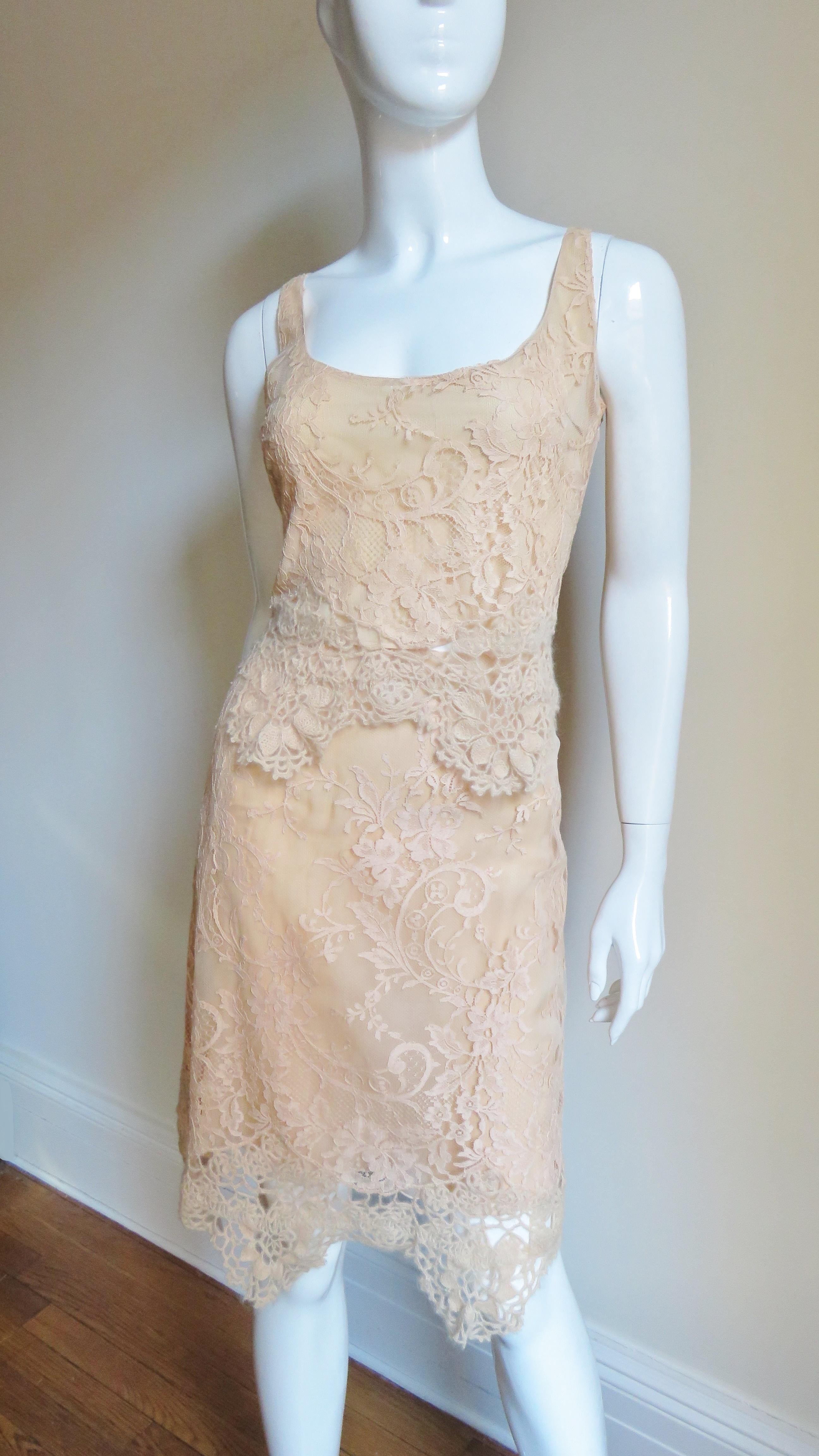 A beautiful 2 piece peach beige silk flower lace skirt and camisole set from Valentino.  The scoop neck lace camisole style top and subtle A line skirt have a horizontal panel of matching knit and crochet flower trim at their hem adding extra