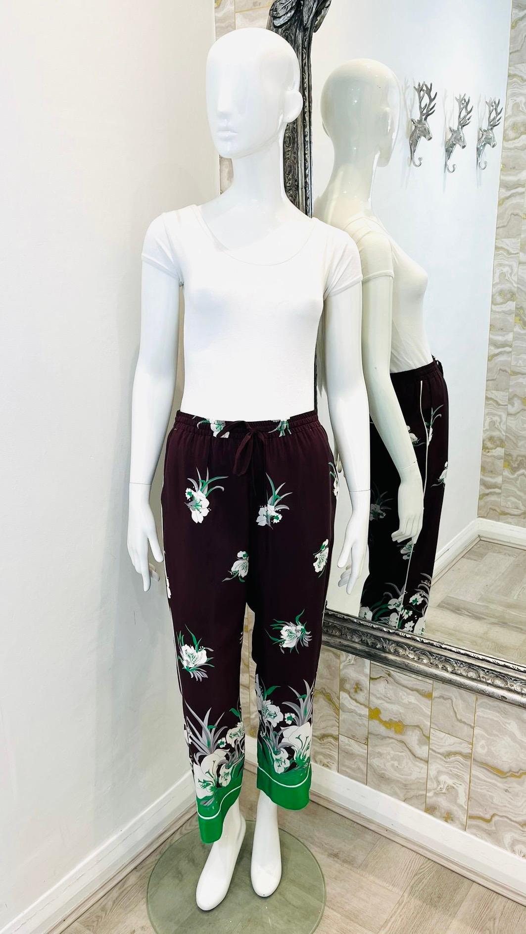 Valentino Silk Printed Trousers

Brown trousers designed with white and green Street Flowers pattern.

Featuring cropped fit, elasticated waist and pockets to rear.

Detailed with 'Valentino' inscription in white to the leg and loose-fit. 

Matching