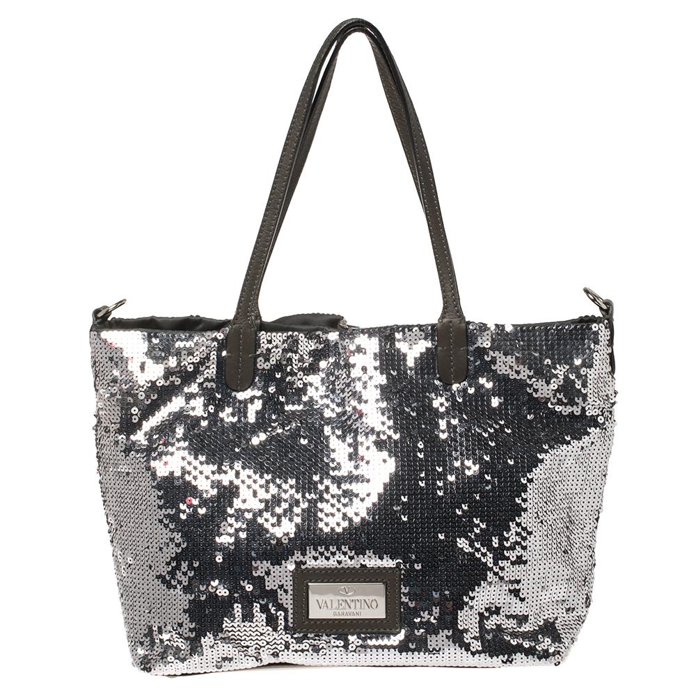 Bags like these are hard to come by, so quickly grab one when you can! Crafted from olive green leather and silver-hued sequins, this bag by Valentino features a beautiful rose detailing on the front. Equipped with dual leather handles, it has a
