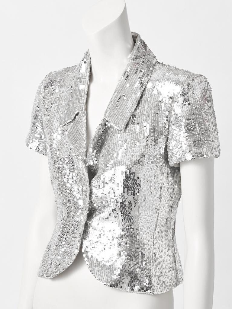 Valentino, fitted jacket, having lapels, short sleeves, a curved hem with crystal button closures. Jacket is entirely, encrusted with silver paillettes.