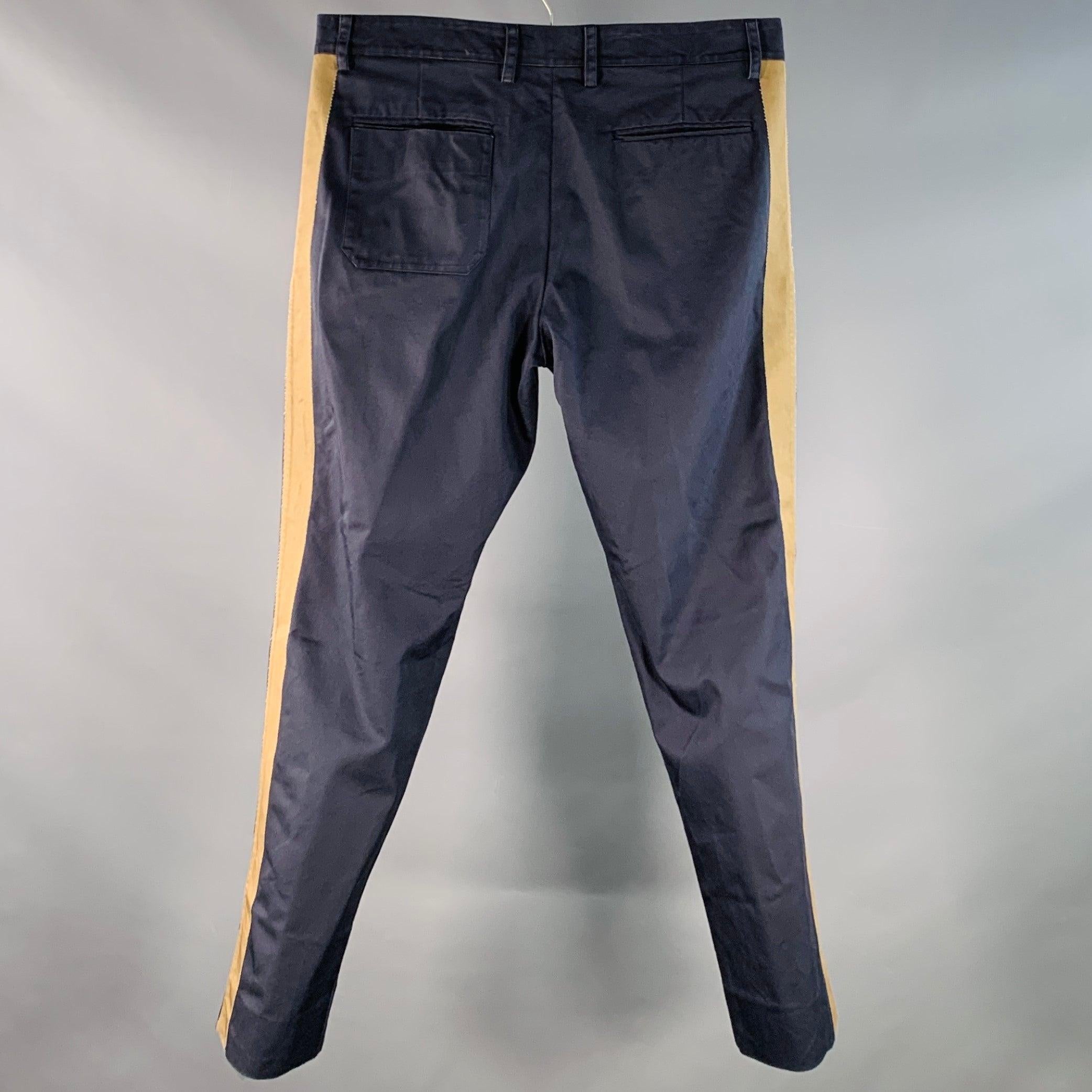 VALENTINO Freizeithose
aus navyfarbenem Baumwoll-Twill mit breiten beigen Seitenstreifen, spitz zulaufendem Bein und Reißverschluss.
Made in Italy. sehr guter gebrauchter Zustand. Leichte Pillingbildung und Gebrauchsspuren. 

Markiert:   IT 46