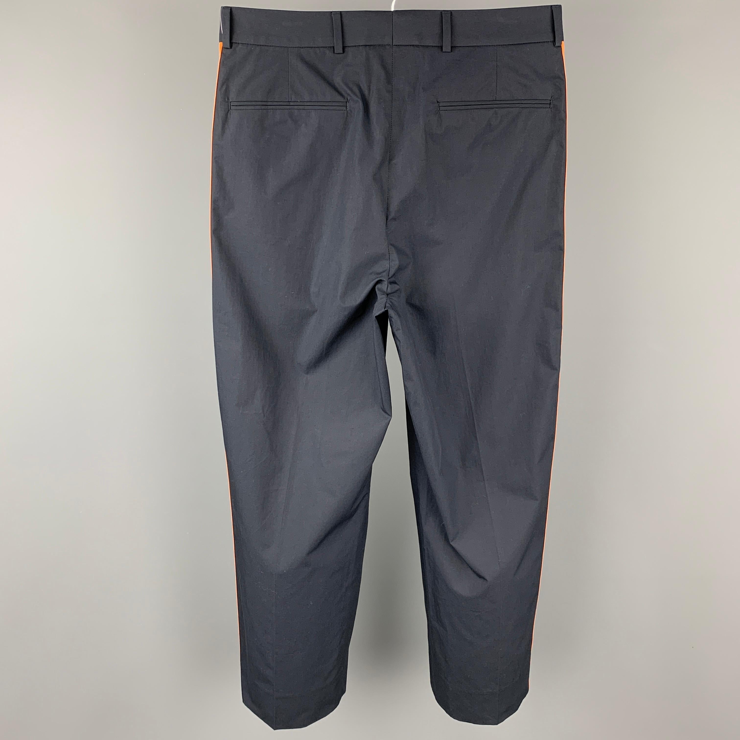 VALENTINO dress pants comes in a navy cotton with a orange stripe trim featuring a pleated style, slit pockets, front tab, and a zip fly closure. Made in Italy.

New With Tags. 
Marked: IT 46

Measurements:

Waist: 31 in.
Rise: 12 in.
Inseam: 26 in. 