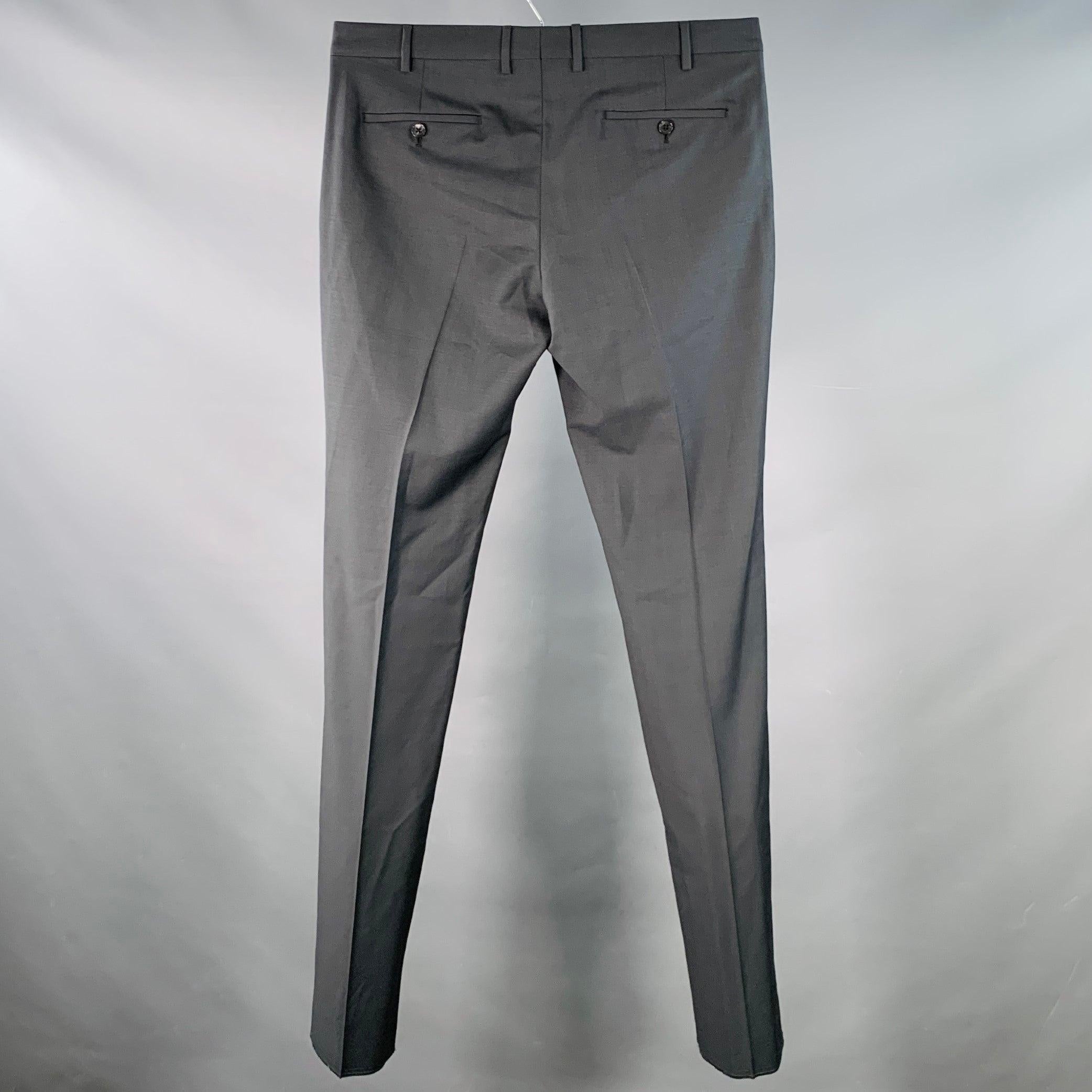 Pantalon habillé Valentino
en laine mohair gris anthracite, avec un devant plat, une jambe fuselée et une braguette boutonnée. L'ourlet n'a pas été fini pour permettre une adaptation parfaite à votre morphologie. Fabriqué en Italie. Nouveau avec