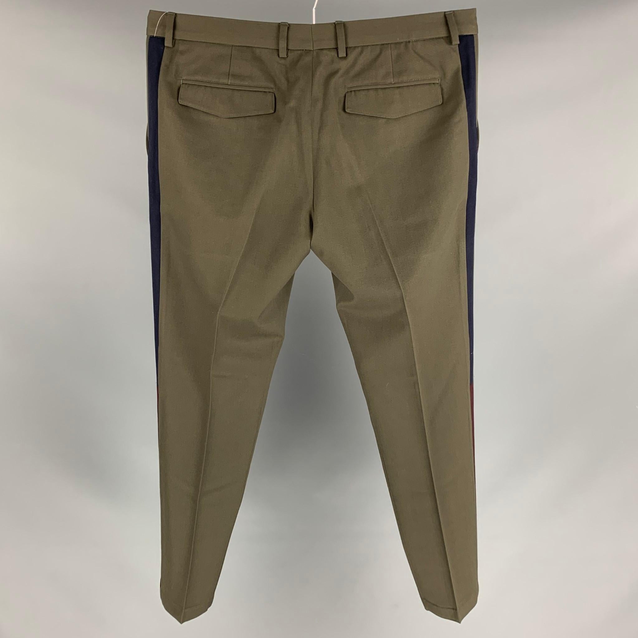 VALENTINO dress pants comes in a olive wool with a tuxedo stripe featuring a slim fit and a zip fly closure. Made in Italy. 

Very Good Pre-Owned Condition.
Marked: 50

Measurements:

Waist: 36 in.
Rise: 10 in.
Inseam: 29 in. 