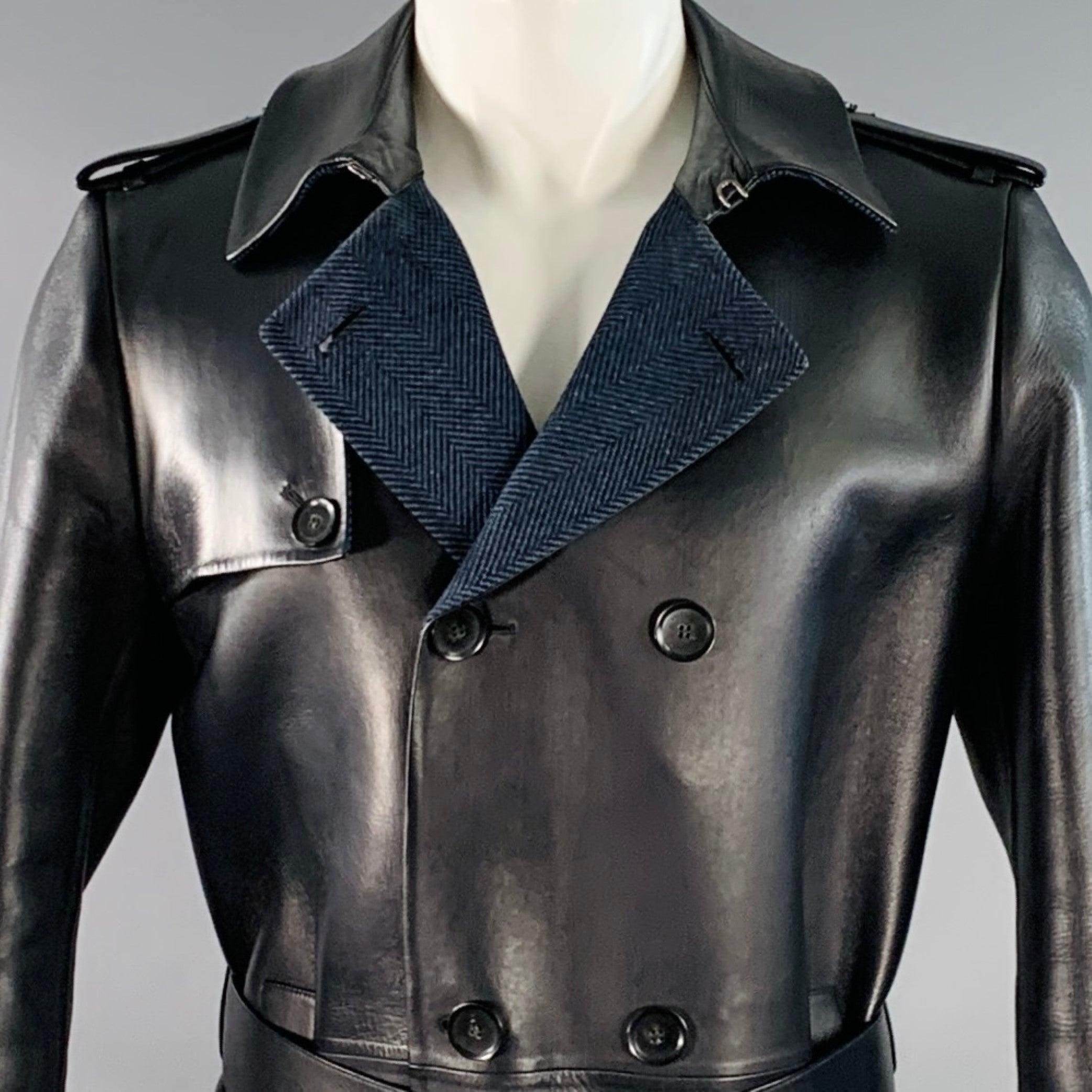 Trench-coat double boutonnage VALENTINO en cuir d'agneau lisse d'un bleu marine profond, avec col pointu, rabat tempête, double poche frontale, épaulettes, manches ceinturées avec boucles en cuir, ceinture à la taille, et doublure à chevrons en