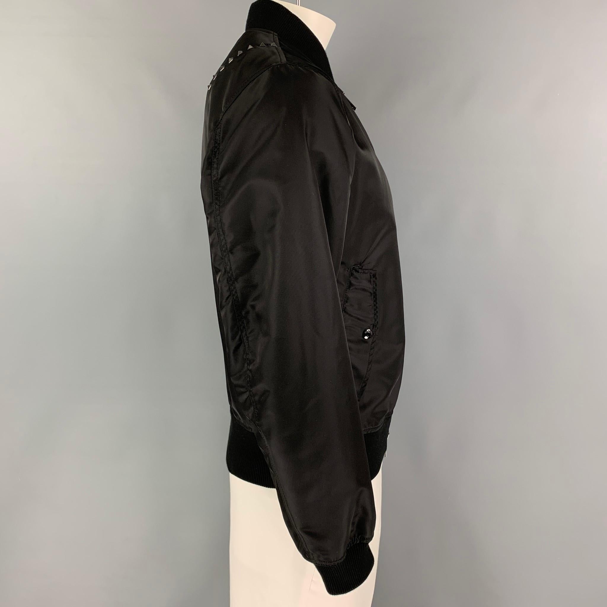 VALENTINO jacket comes in a black polyamide featuring a bomber style, studded embellishments, flap pockets, ribbed hem, and a full zip up closure. Made in Italy. 

Excellent Pre-Owned Condition.
Marked: I 50 / US 40 / F 50

Measurements:

Shoulder: