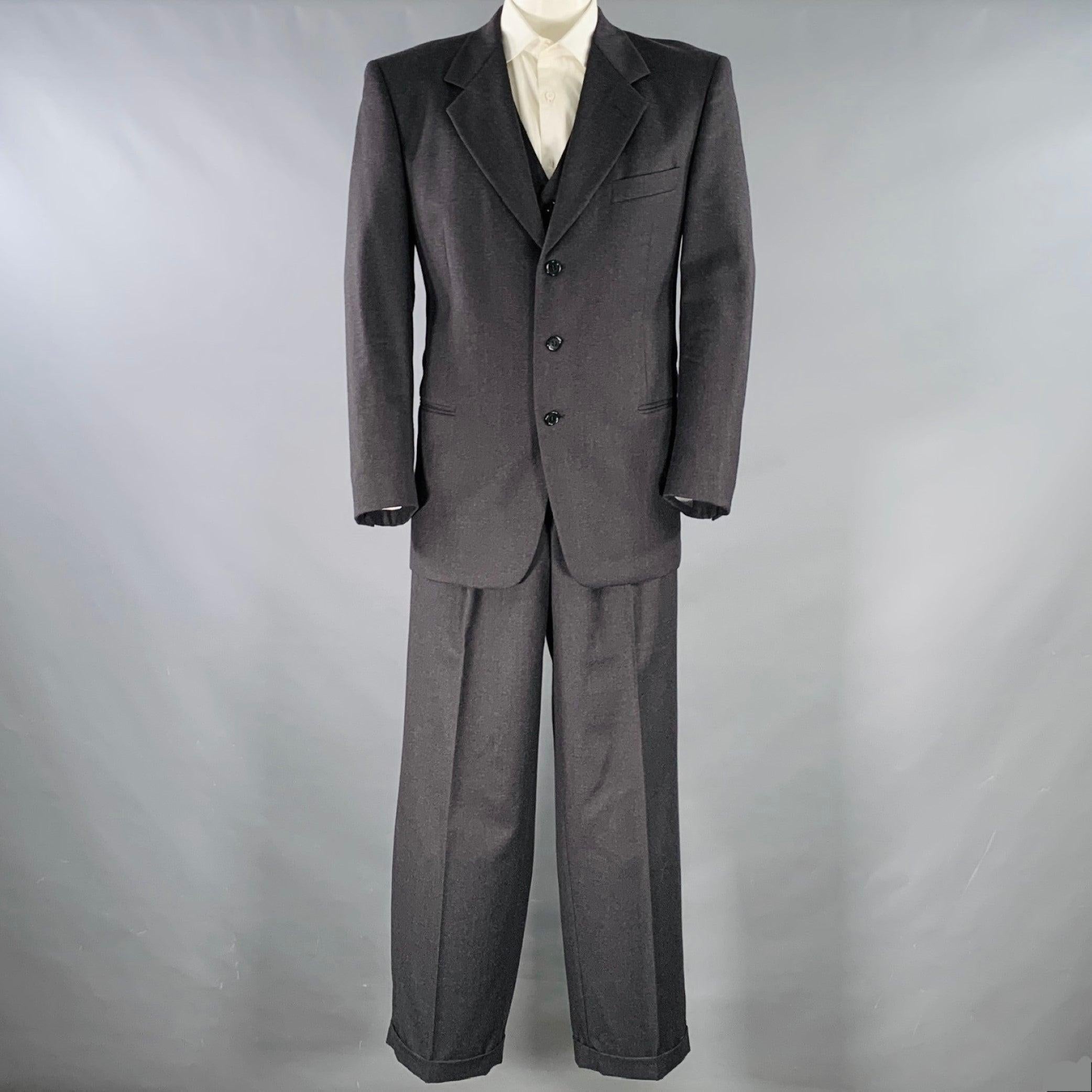 Vintage VALENTINO for SAKS FIFTH AVENUE costume trois pièces
en laine vierge gris anthracite avec une doublure complète et comprend un manteau sport à trois boutons à simple boutonnage avec un revers à cran, un gilet assorti et un pantalon à plis.