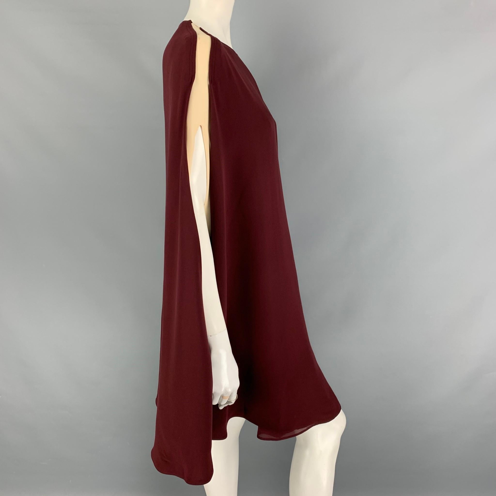 VALENTINO 'Light Cady' dress comes in a burgundy & cream two toned silk featuring a cape style, contrasting bands at the sides, and a back single button closure. Made in Italy. 

Very Good Pre-Owned Condition. Light marks at shoulder.
Marked: