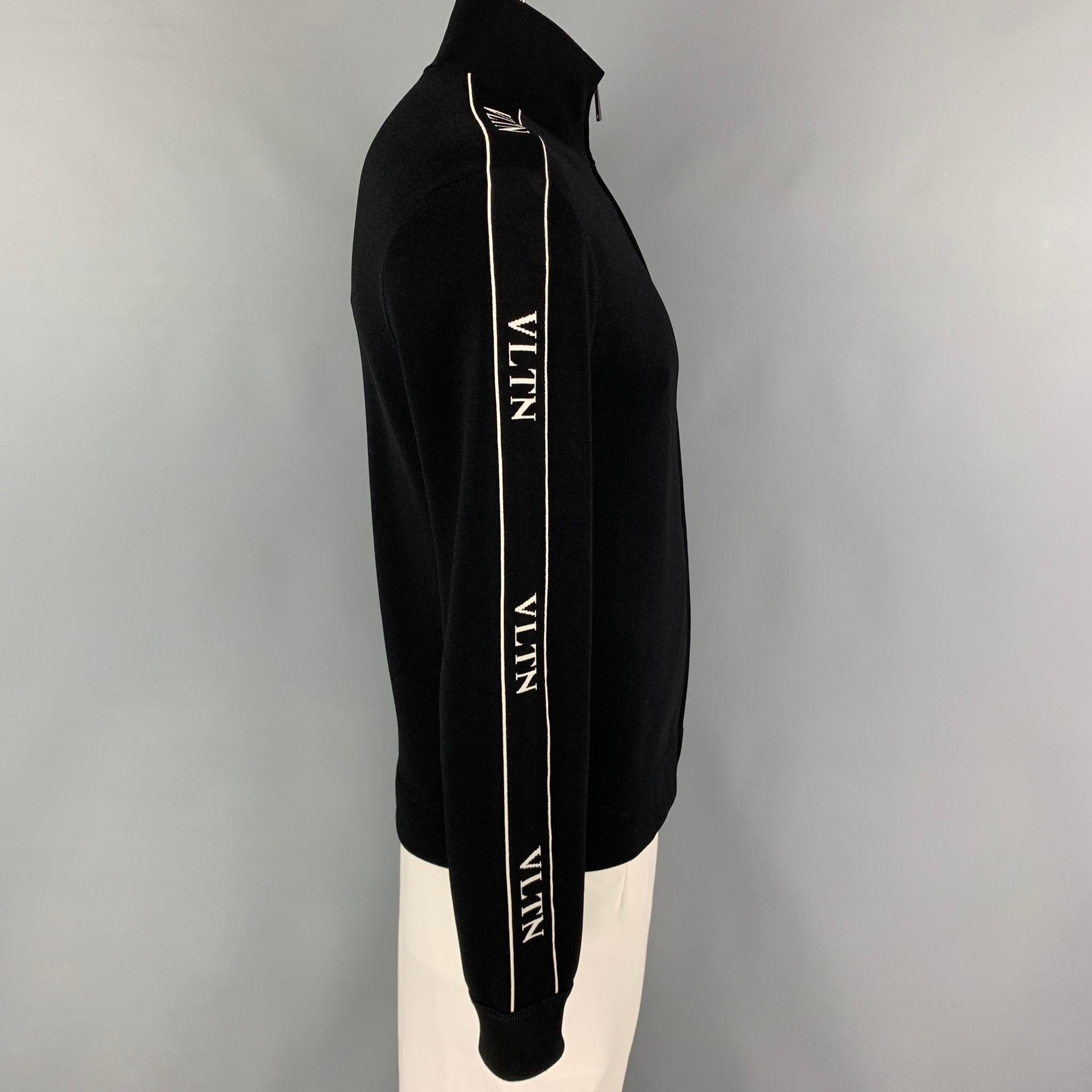 VALENTINO jacket comes in a black viscose blend with white logo details featuring a high collar, slit pockets, and a full zipper closure. Made in Italy. 

Excellent Pre-Owned Condition.
Marked: L

Measurements:

Shoulder: 19 in.
Chest: 40