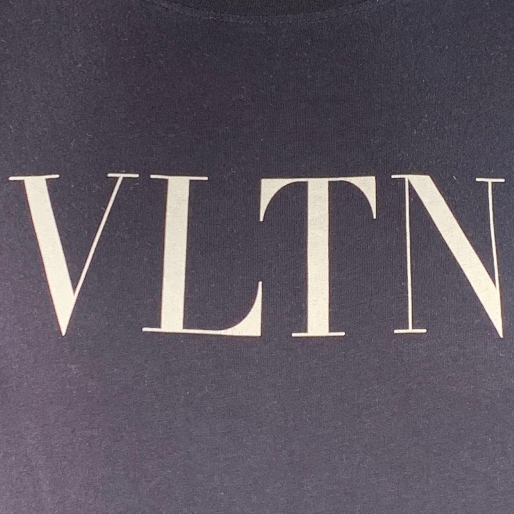 VALENTINO T-Shirt 2019 aus marineblauem Baumwolljersey mit weißem VLTN-Logo-Print, kurzen Ärmeln und Rundhalsausschnitt. Made in Italy Ausgezeichneter Pre-Owned Zustand.  

Markiert:   L 

Abmessungen: 
 
Schulter: 20 Zoll Brust: 42 Zoll Ärmel: 8,25