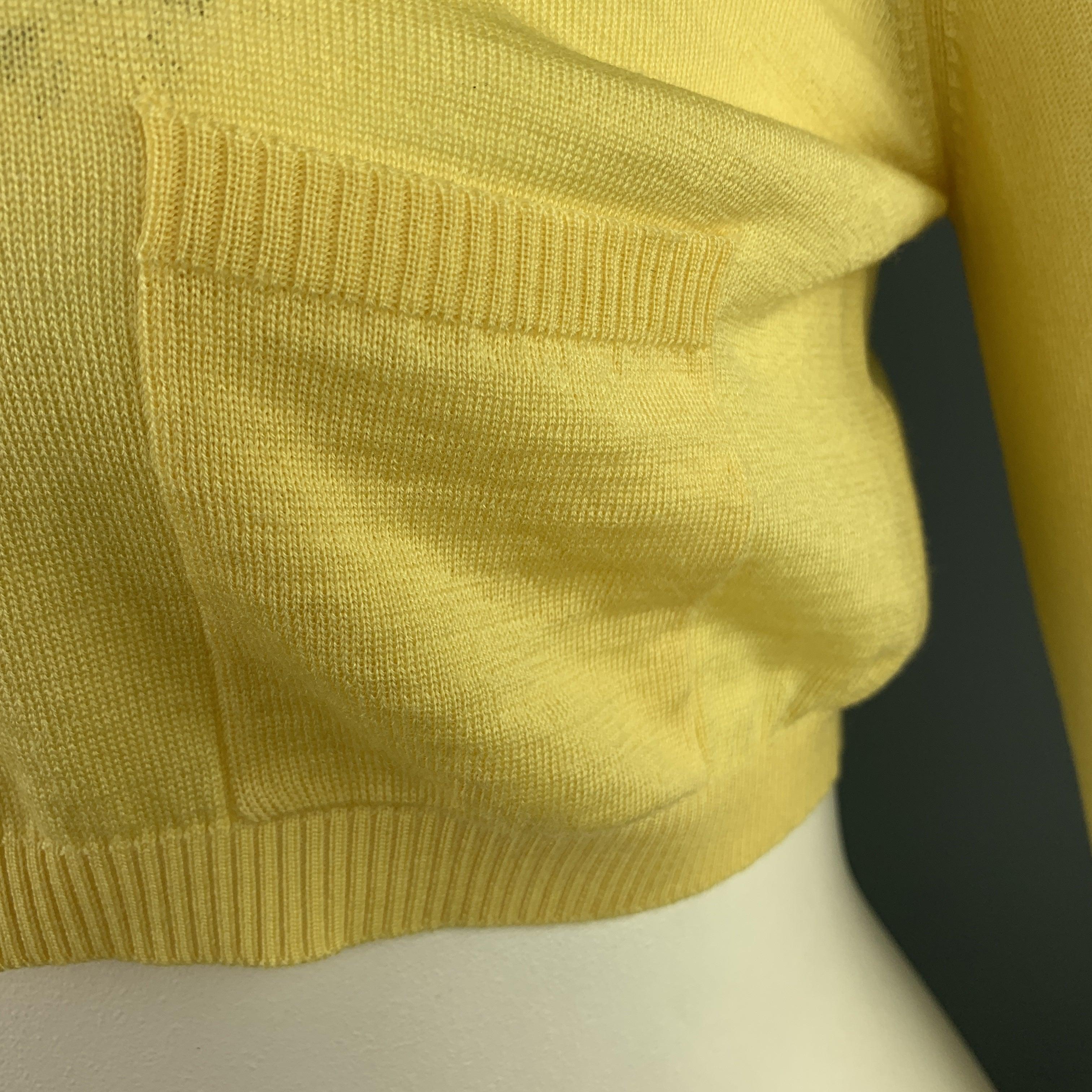 VALENTINO cardigan comes in pastel yellow wool blend knit with a round neck, cropped hem, and patch pocket. Made in Italy.
Very Good
Pre-Owned Condition. 

Marked:   L 

Measurements: 
 
Shoulder: 16 inches Bust:
36 inches Sleeve:
18 inches Length: