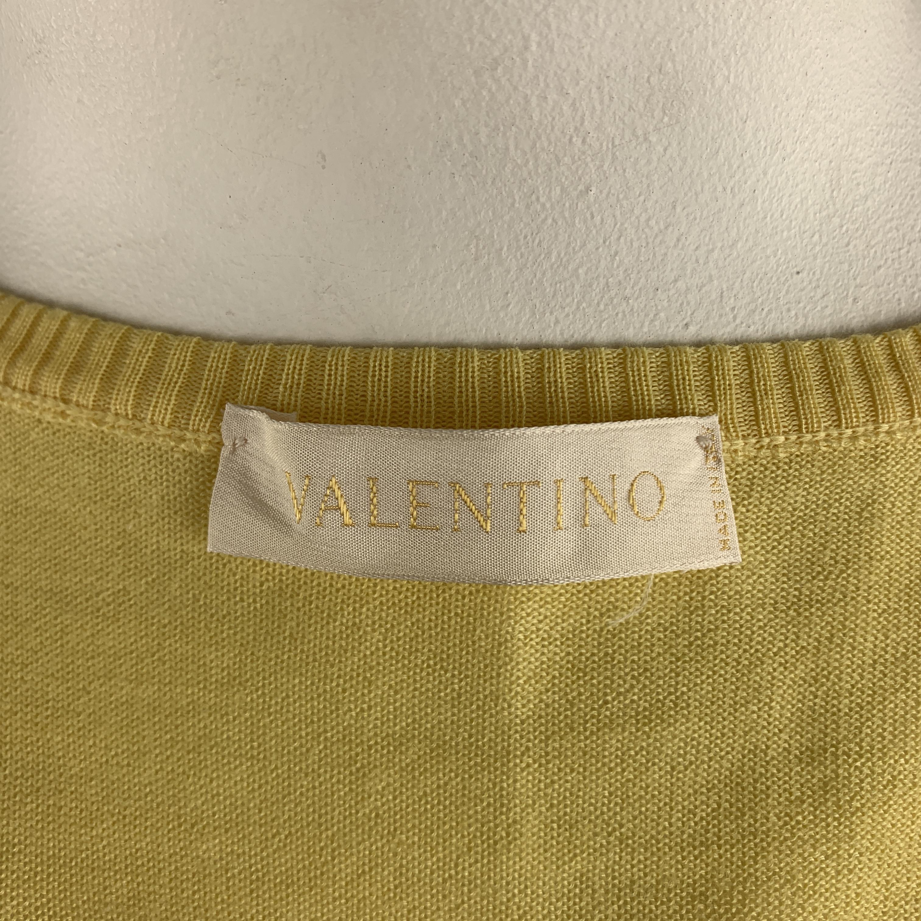 VALENTINO cardigan comes in pastel yellow wool blend knit with a round neck, cropped hem, and patch pocket. Made in Italy.
Very Good Pre-Owned Condition.
Marked: L

Measurements:

Shoulder: 16 in.
Bust: 36 in.
Sleeve: 18 in.
Length: 14.5 in.