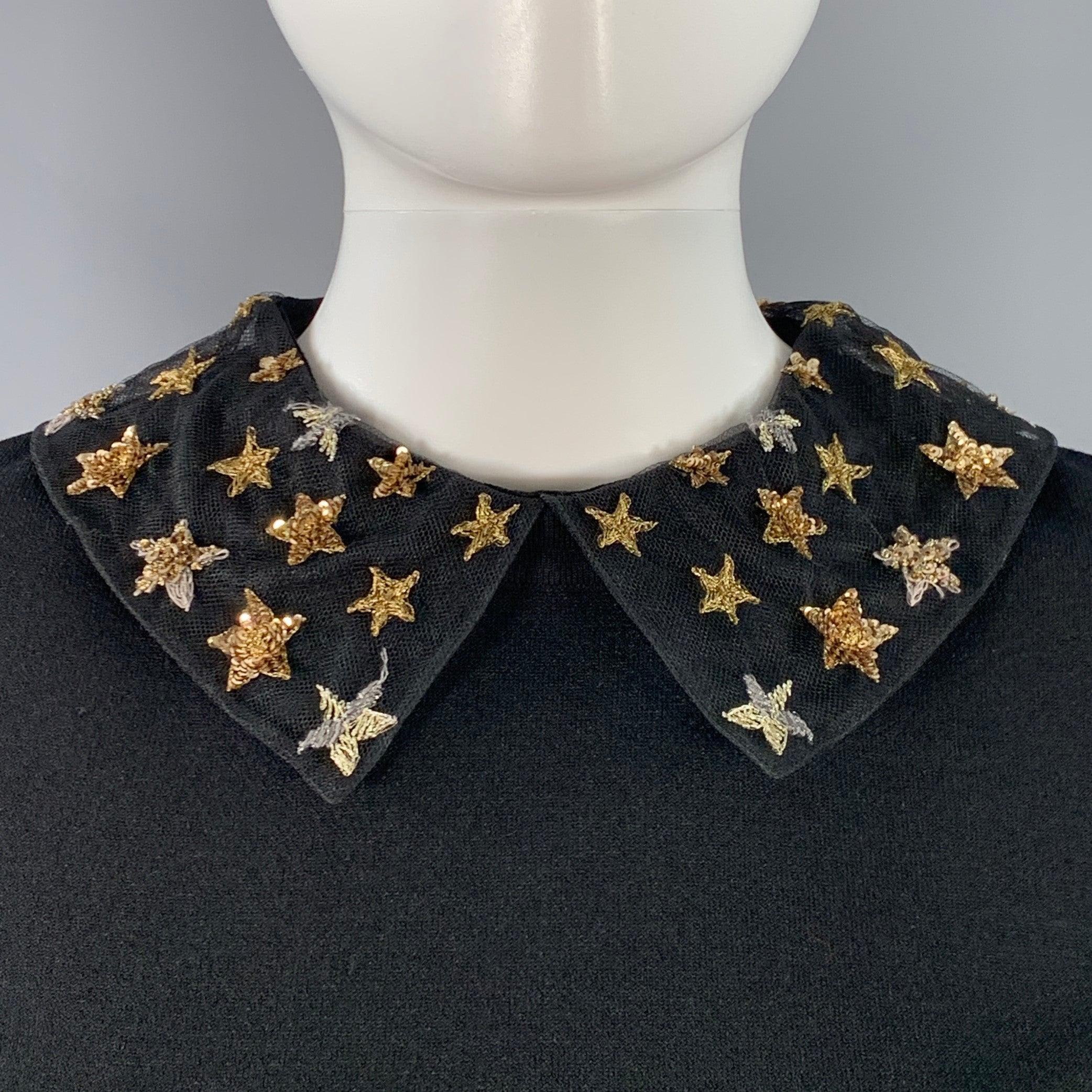 Robe VALENTINO
en viscose extensible noire, avec un col Peters en maille et des appliques d'étoiles dorées et argentées, des rayures métalliques assorties à la taille et une fermeture à glissière invisible au dos. Fabriqué en Italie. Très bon état.