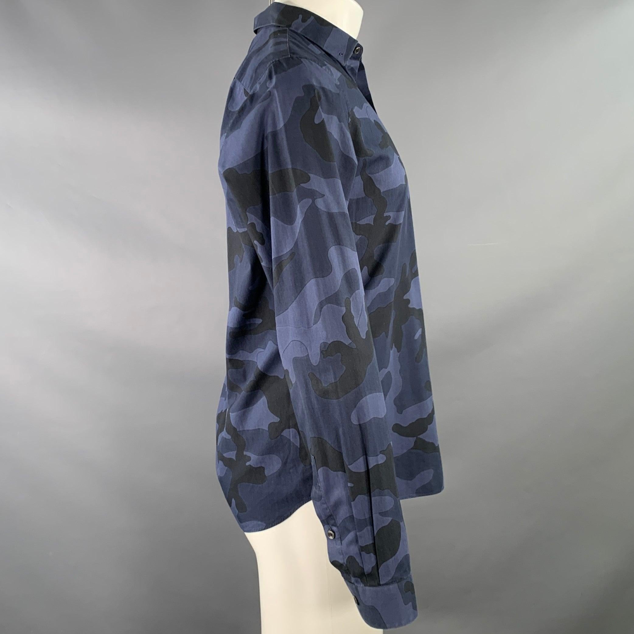 VALENTINO long sleeve shirt
in a navy and black cotton woven fabric featuring a camouflage pattern, and button closure.Good Pre-Owned Condition. Signs of wear on collar: missing one stud and moderate signs of wear on other stud. As is. 

Marked:  