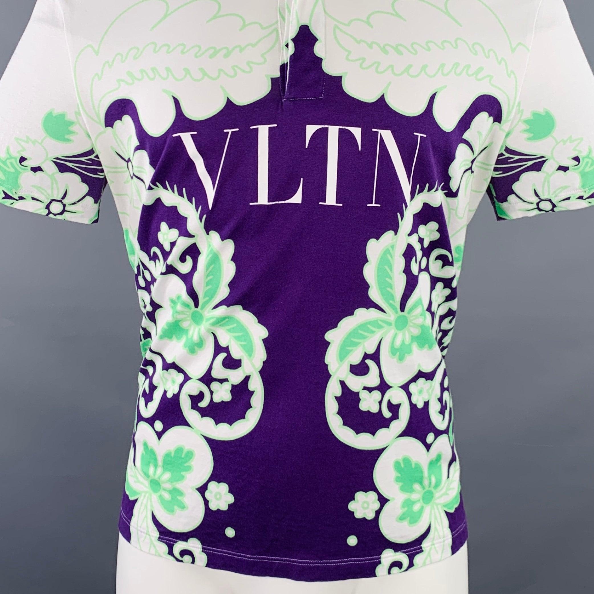 Polo VALENTINO
en jersey de coton blanc, avec un imprimé floral abstrait violet et vert, le logo VLTN et une demi-patte de boutonnage cachée. Fabriqué en Italie. Très bon état.
 Signes d'usure sur le logo VLTN. 

Marqué :   taille non marquée,