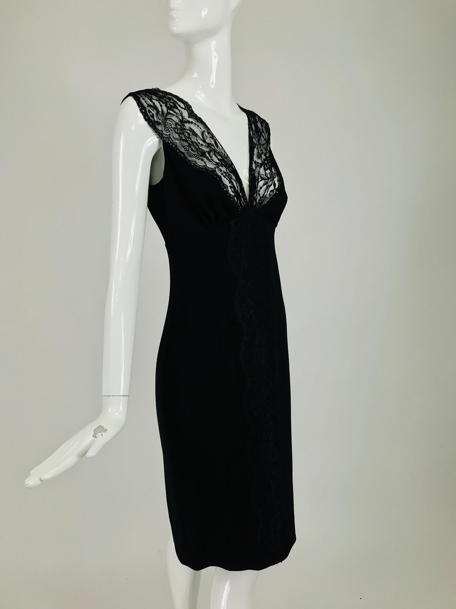Valentino sleeveless black sheath with black lace décolletage. Plunge V bodice with unlined black lace facings, empire waist, the skirt is semi fitted. Back center hem vent. Black flat wool with some stretch. Fully lined in black acetate. Closes at