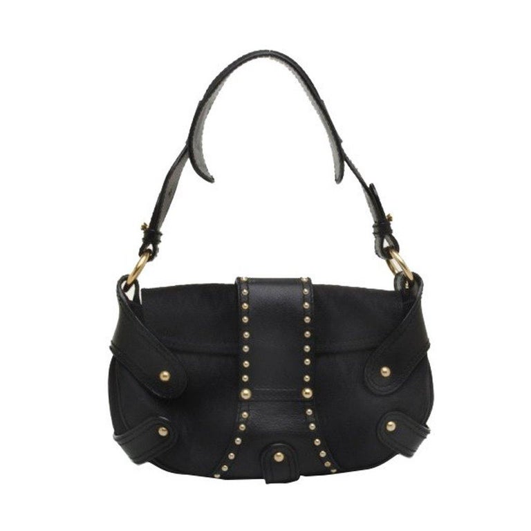 This studded handbag by Italian Designer Valentino is not your average little black bag. The bag is made from monogrammed canvas and leather trim with golden studs that create an appealing edgy look. This handbag also features a comfortable leather