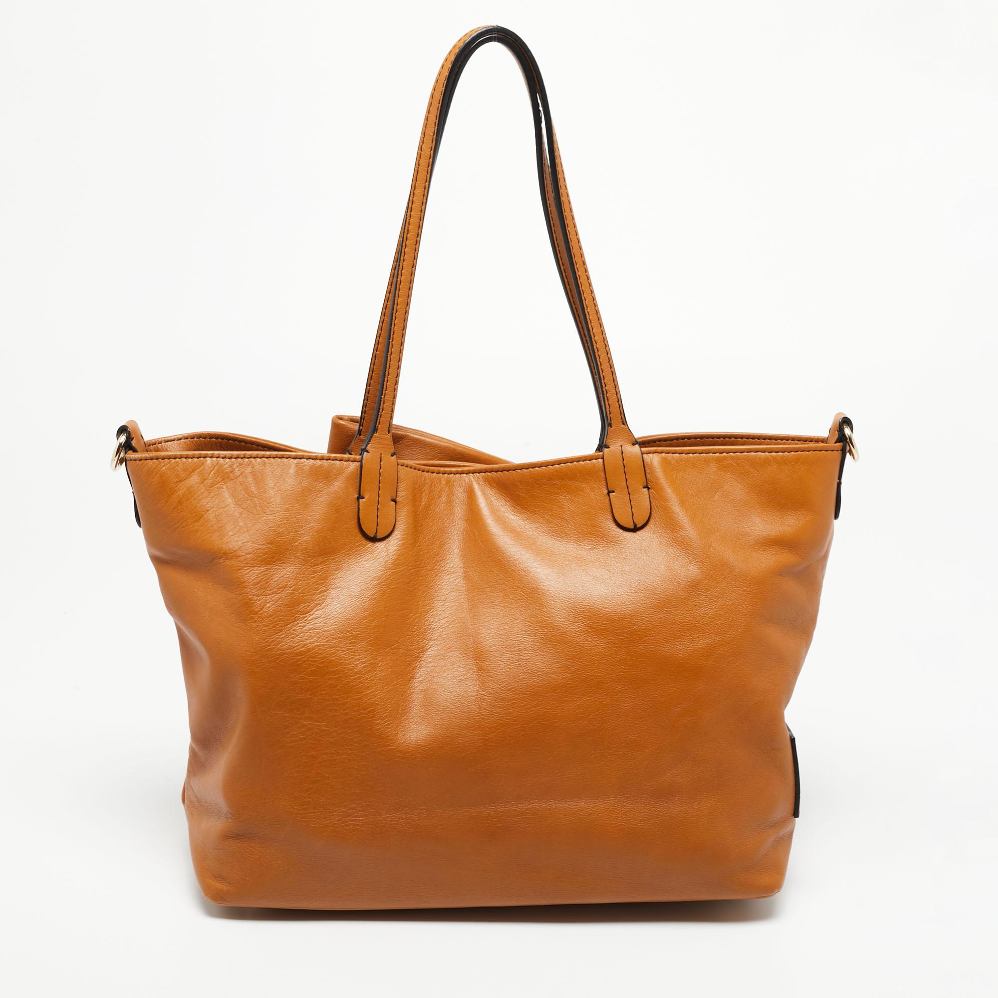 This tote from the House of Valentino is stylish, sturdy, and practical for everyday use. It is crafted using tan leather on the exterior, which is accentuated with a large bow detail on the front. It showcases two handles, gold-toned hardware, and