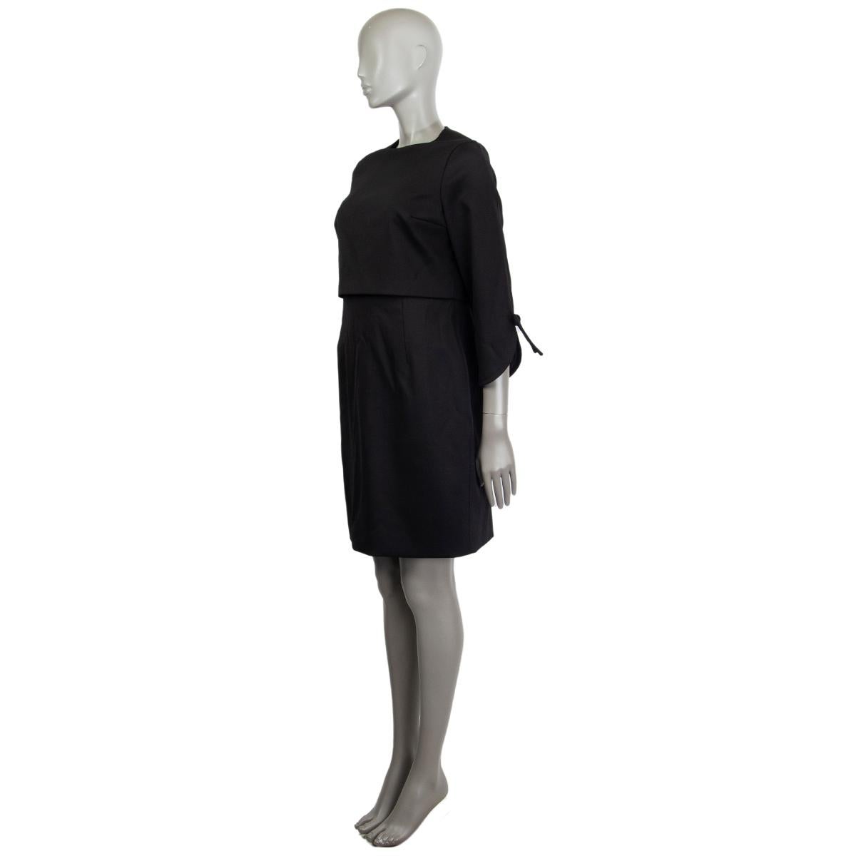 Valentino Techno Couture sheath dress in black missing tag (probably wool blend) with a crop top, round neckline, knee-length, 3/4 arm length detailed with a slit and ribbon on the outside. Lined in black fabric missing tag. Closes with a concealed