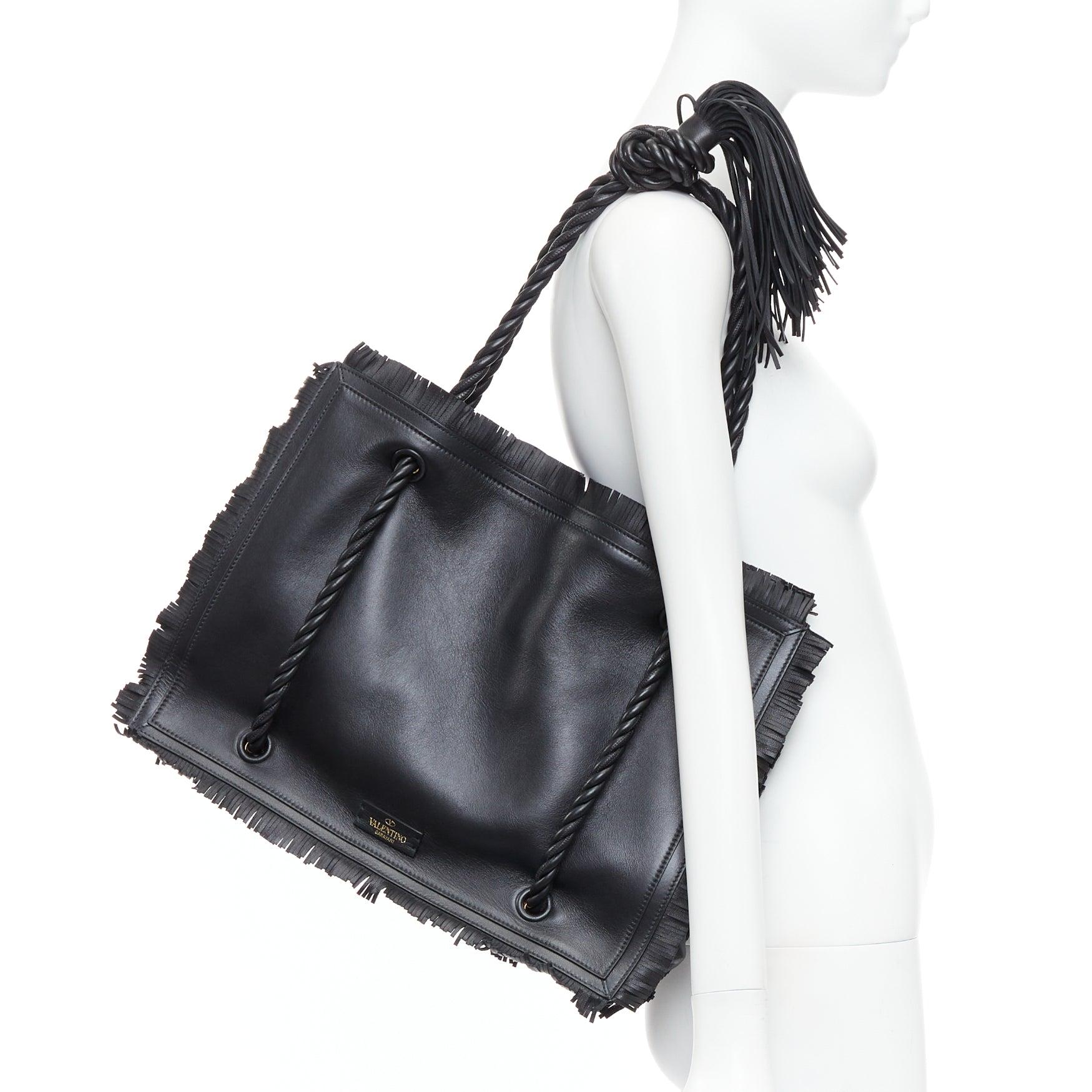 VALENTINO The Rope black fringe leather braided rope handle large tote bag
Reference: AEMA/A00112
Brand: Valentino
Designer: Pier Paolo Piccioli
Model: The Rope
Collection: SS2020
Material: Leather
Color: Black, Gold
Pattern: Solid
Lining: Red