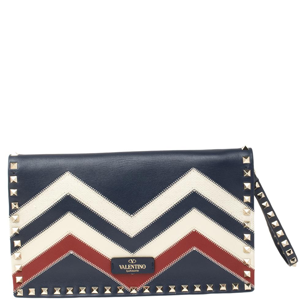 The clutch to buy today is this one by Valentino! Crafted with expertise, the creation has chevron patterns achieved using leather and canvas, a spacious interior, and signature studs lined on the exterior. It can be carried with the hand slot or