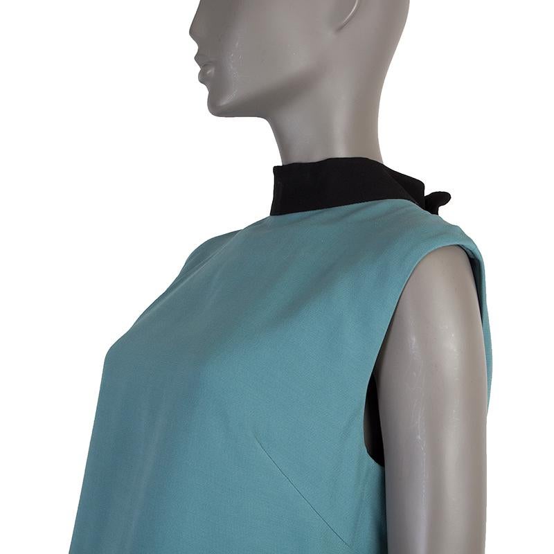 Valentino high-neck shift dress in turquoise and black wool (68%) and silk (32%). With two slit pockets on the sides, box pleat on the back, and bow on the back of the neck. Closes with hook, invisible zipper and one snap on the back. Lined in