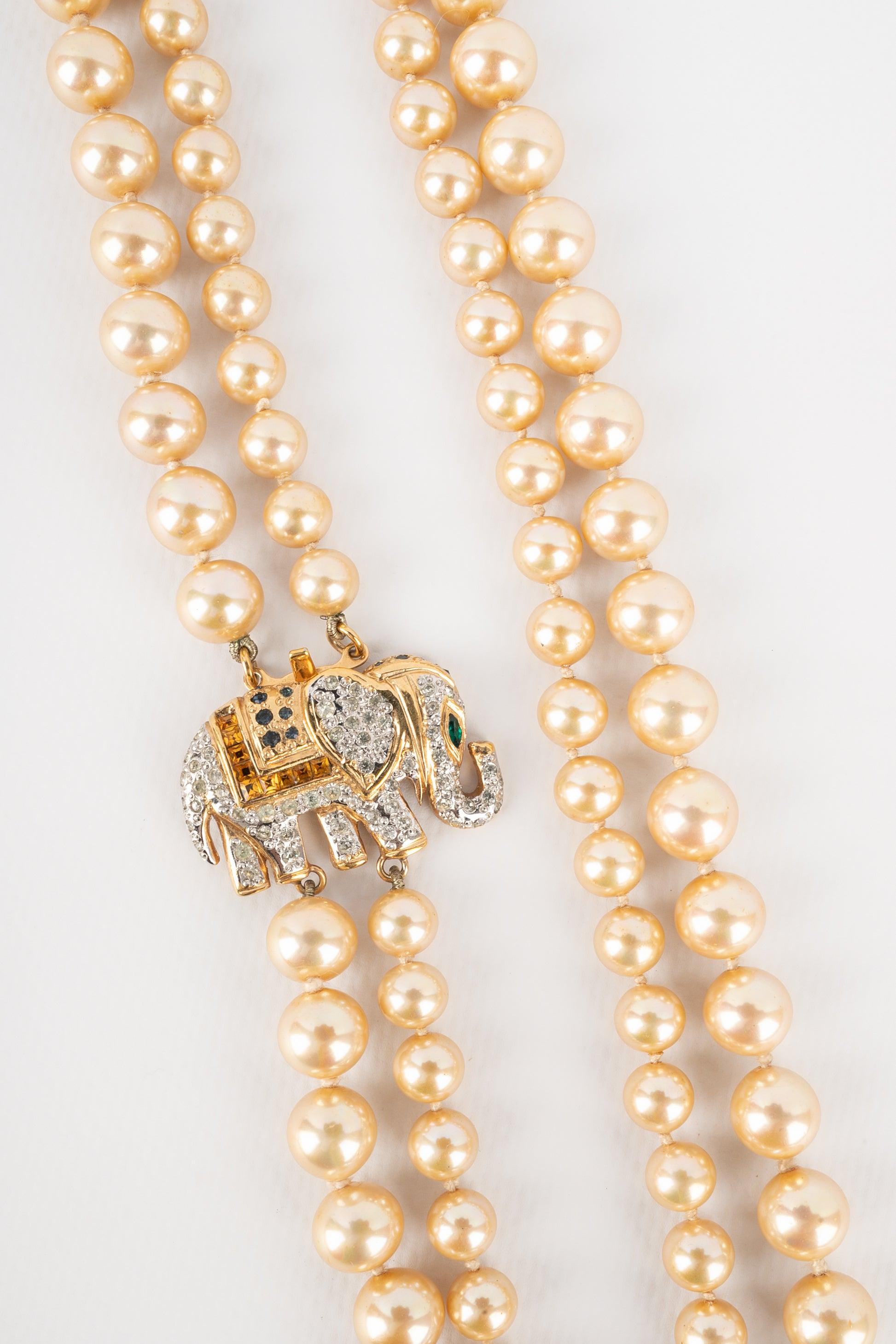 Valentino - Two-row costume pearl necklace assembled with knots, with a golden metal and rhinestone fastener representing an elephant. Jewelry from the 1980s.

Additional information:
Condition: Very good condition
Dimensions: Length of the shorter