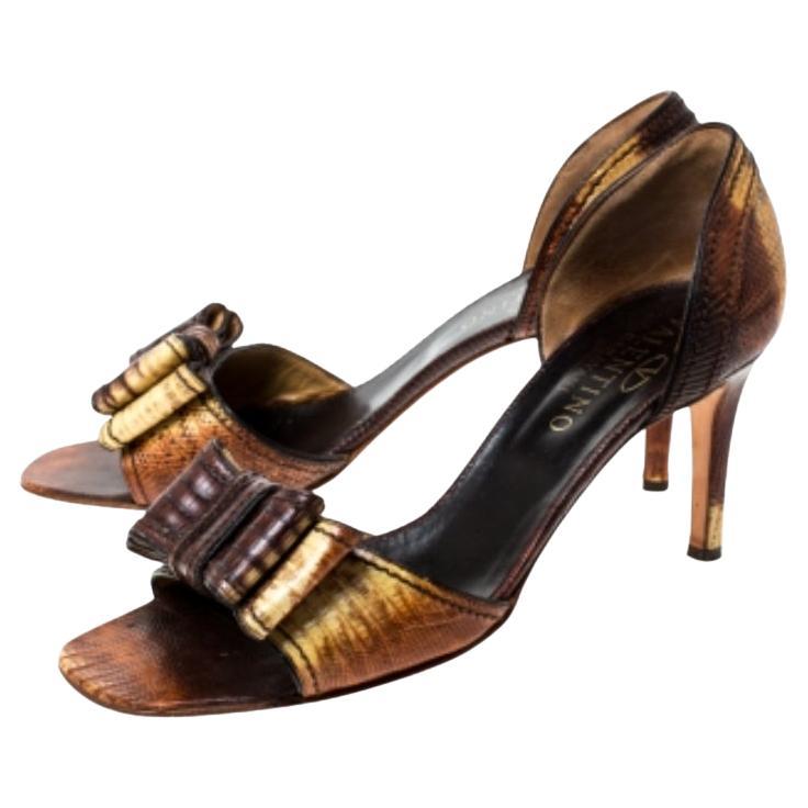 Feminin, stilvoll und wunderschön - diese Sandalen von Valentino sind ein absolutes Must-have. Ihr elegantes Design ist aus Eidechsenleder in zweifarbigem Braun und strukturiertem Finish gefertigt. Sie sind mit Schleifen auf dem Vorderblatt und
