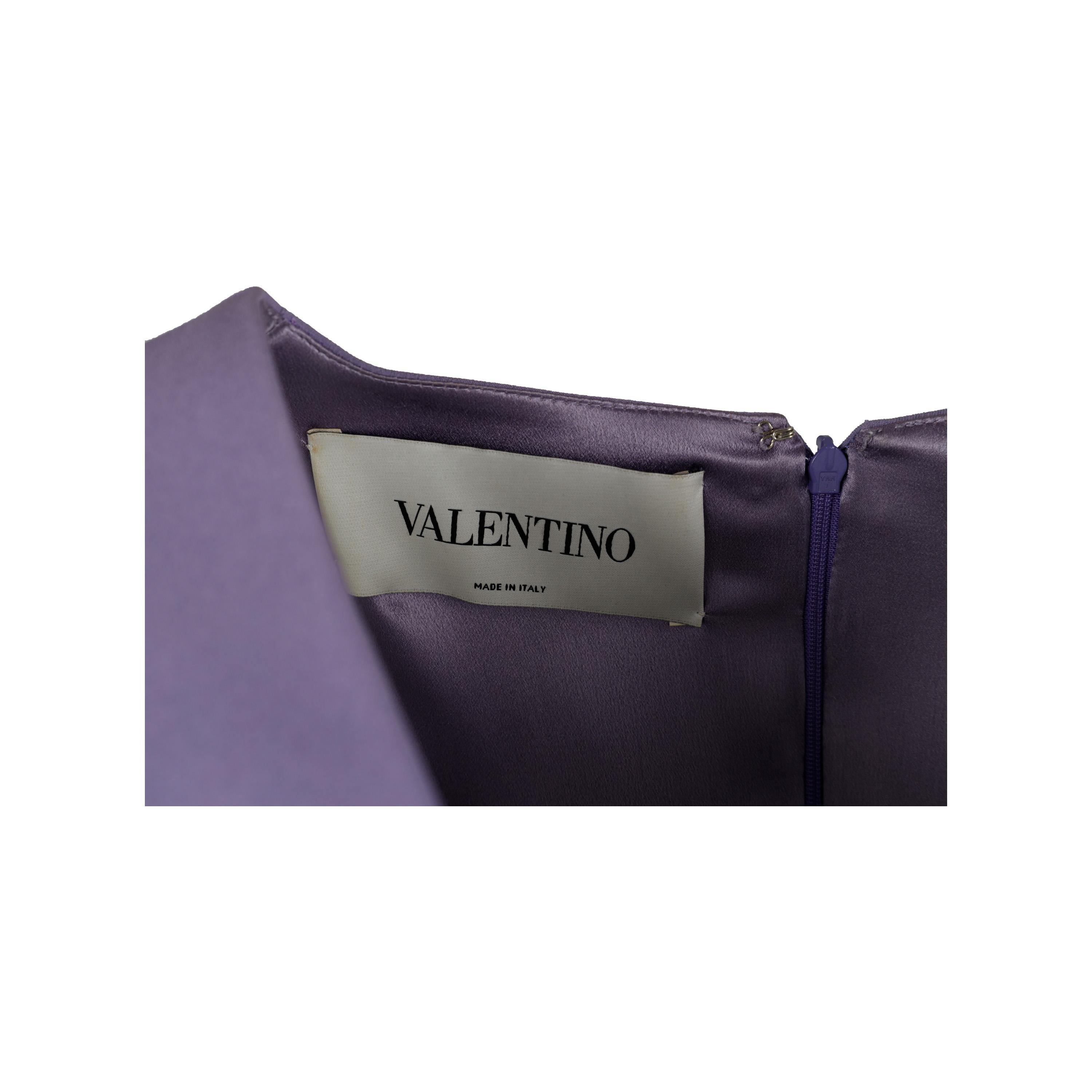 Featuring a lavish lavender hue, this Valentino dress is perfect for a special occasion. This short-sleeved midi dress features a V neck enhanced by pleated details and a zip closure at the back for the perfect fit.

Remarks: The size and