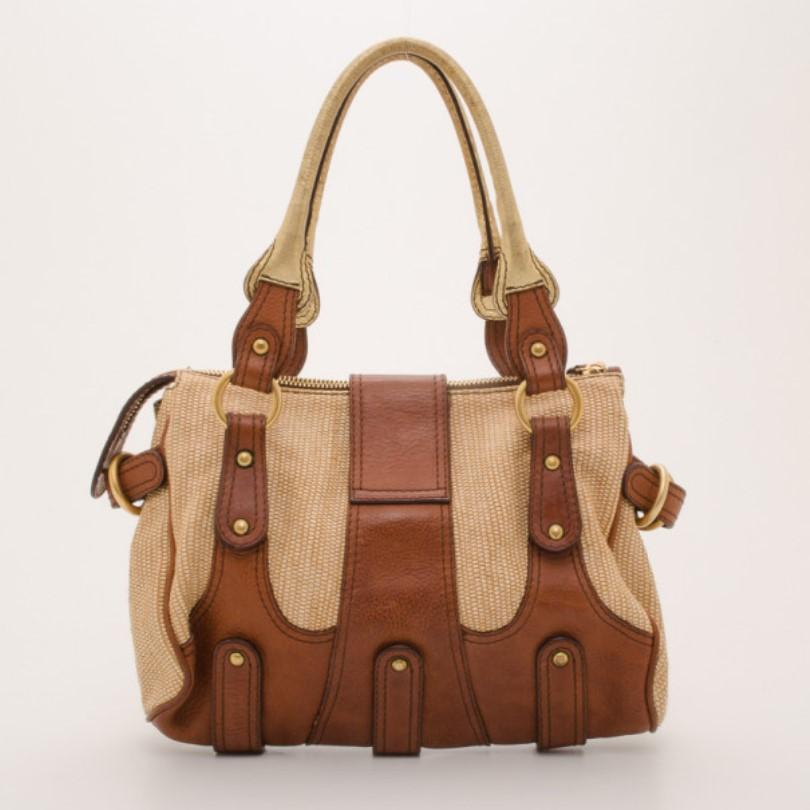 Go for a wearable yet adventurous look with this V woven leather satchel from Valentino. Crafted from woven leather with smooth brown leather trim, the exterior is detailed with a large jeweled gold Valentino logo, gold hardware, rolled gold leather