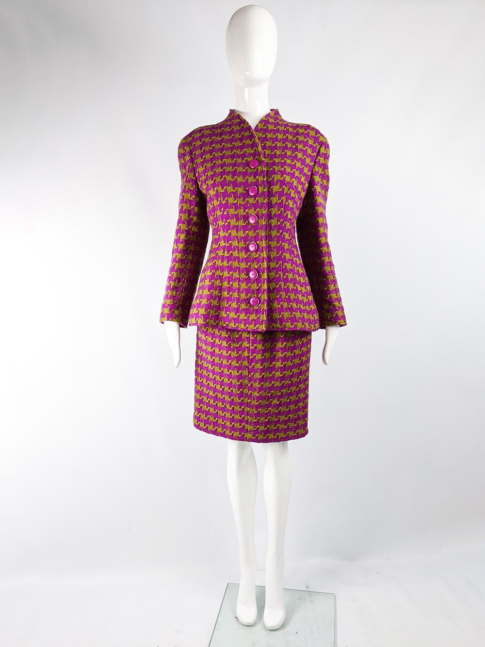 An incredibly chic vintage womens skirt suit from the 80s by Valentino. In a fuchsia and olive green houndstooth check tweed with shoulder pads that puff out the top of the sleeves without adding bulk and a jacket that flares out at the hips.
