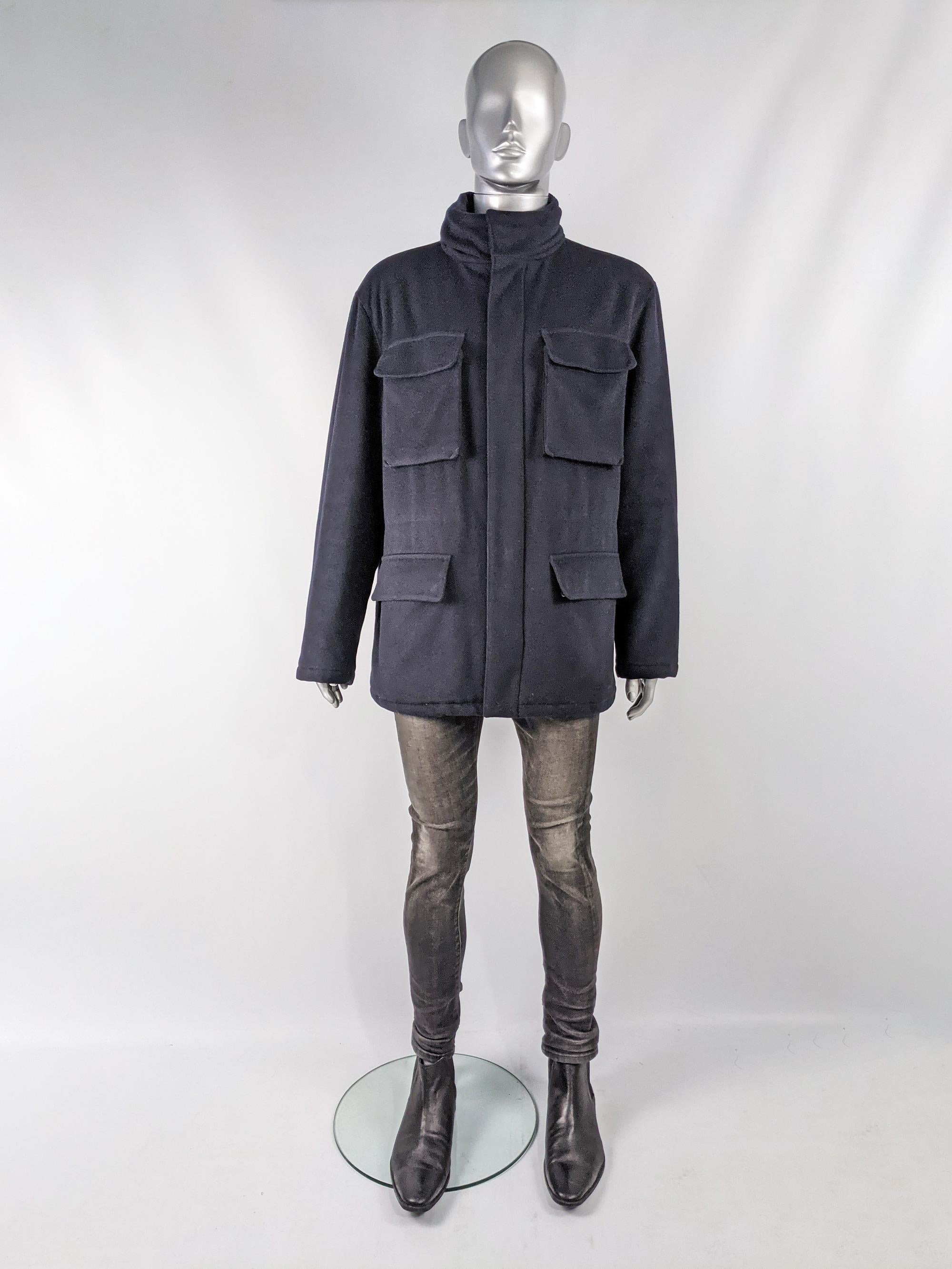 An amazing and rare vintage Valentino mens coat from the 90s in a navy blue wool and cashmere fabric with four excellent utility style pockets, a drawstring on the interior that pulls in the waist for a trimmer silhouette and a high funnel neck that
