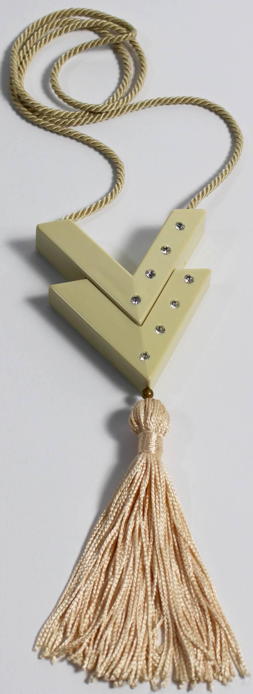 Fabulous vintage Valentino perfume tassel necklace 
This rare and collectable necklace is made of a bakelite type plastic in a champagne beige color.
The cording on the necklace is sturdy and silky feeling.
The pendant is a the letter 