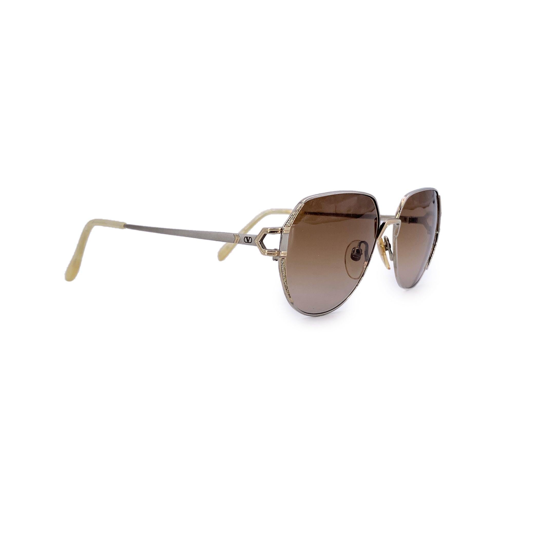 Diese schimmernde Valentino Vintage-Sonnenbrille, Modell 5213, ist ein seltener Fund aus einer Ära, in der Eleganz auf gewagtes Design traf. Der silberne Metallrahmen ist elegant und raffiniert, aber es sind die glitzernden Details an den Seiten,