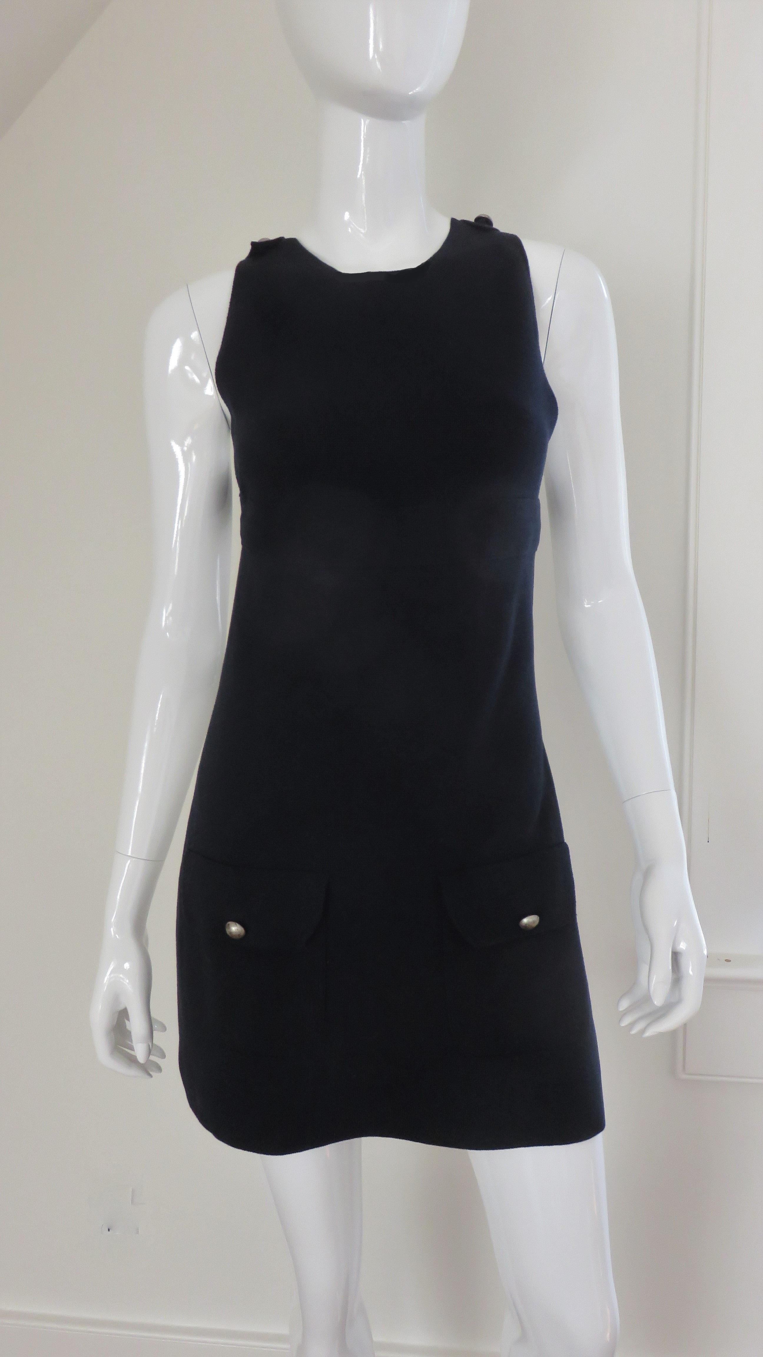 A black wool knit 'apron' top, vest from Valentino.  It has straps at the waist and crossing at the upper back closing with round silver buttons and flap patch pockets.
Fits sizes Small, Medium. Marked size S.


Bust   34-36