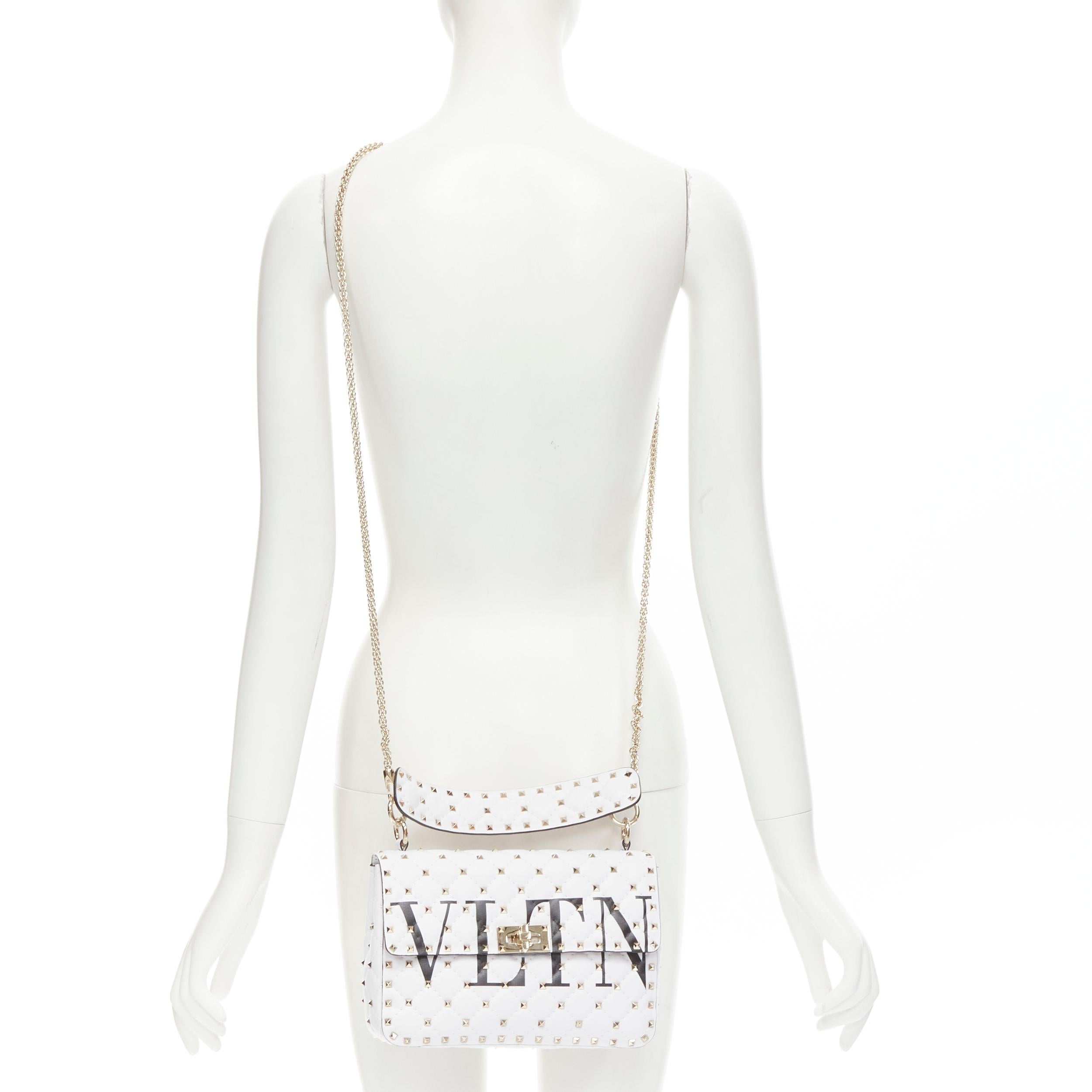 VALENTINO VLTN Rockstud Spike white gold studded turnlock crossbody flap bag Reference: KEDG/A00118 Brand: Valentino Model: VLTN Medium Rocksud Spike Material: Leather Color: White Pattern: Solid Closure: Turnlock Extra Detail: White leather with