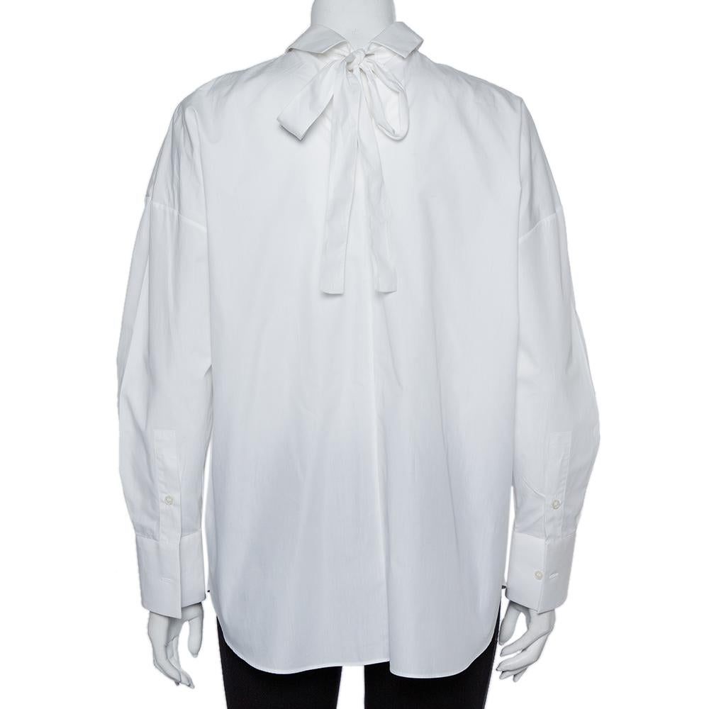 The oversized silhouette and the necktie at the back make this Valentino shirt a covetable piece. It exhibits a simple collar and long sleeves that add a cool quotient to the shirt. Equipped with button fastenings, wear this one for an effortless