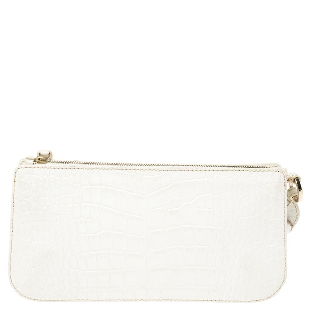 Well-designed in a simple shape, this wristlet pouch from Valentino will be a worthy buy. This white piece is made with croc-embossed leather and is enhanced with gold-tone hardware details, a wristlet, and a satin-lined interior.