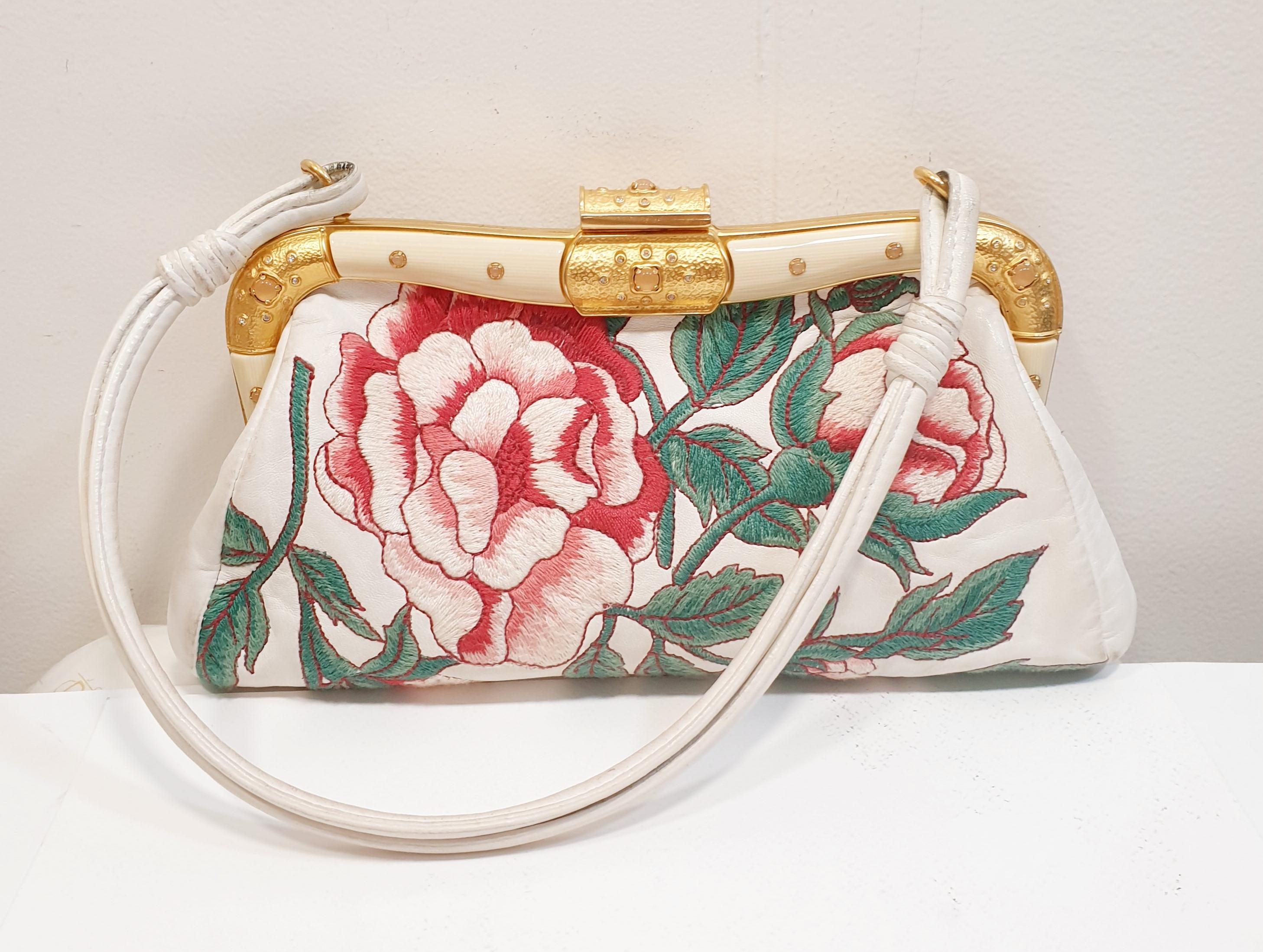 Valentino White  Leather Floral Embroidered Frame Baguette Bag
Jewel Bag that goes with every night special occasion 
 It has been crafted from leather and styled with gold-tone hardware and floral embroidery. 
It comes with a single handle and a