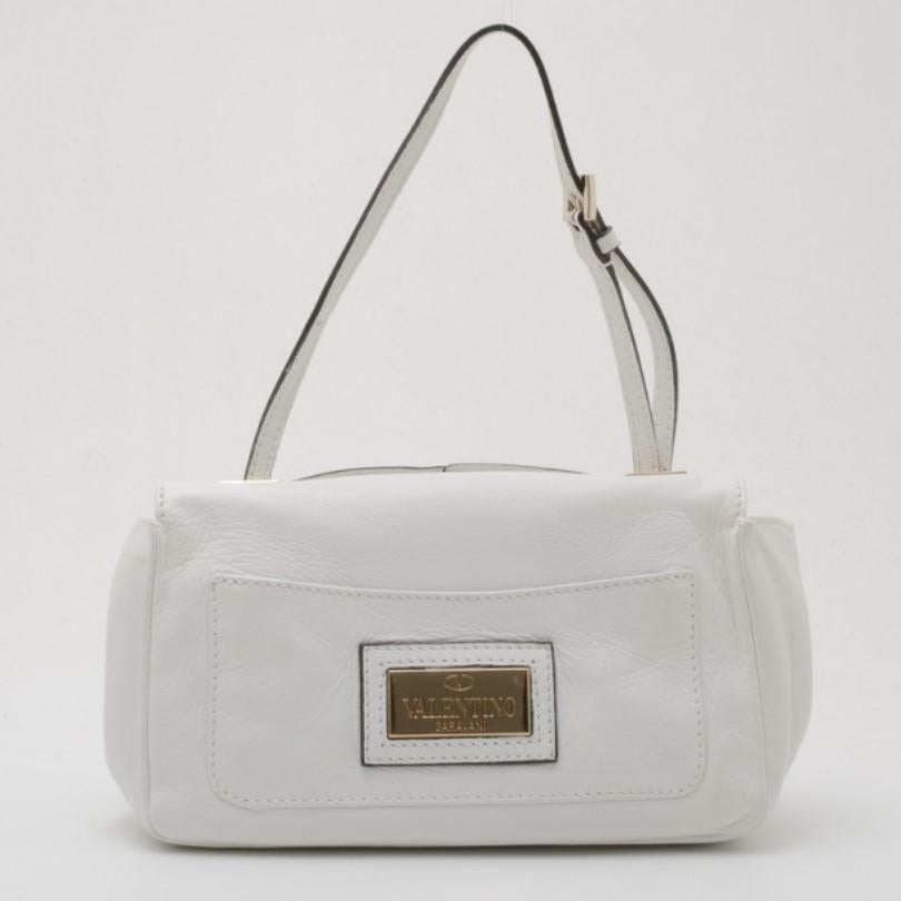 Decorated with a prominent white leather rosette on its big flap, this Valentino Shoulder Bag is sure to grab lots of compliments. This spacious bag holds an open patch pocket and an extra bold monogrammed pocket. It's fastened to an adjustable