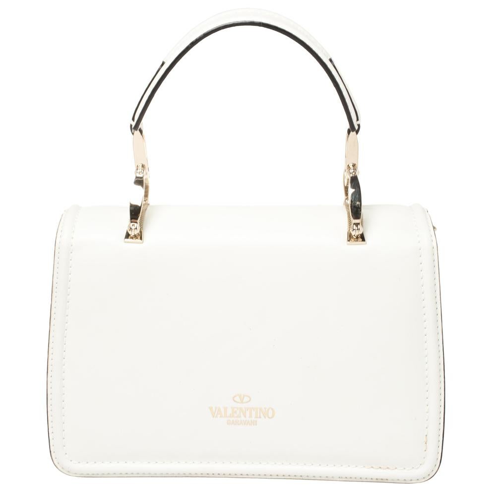 Valentino is one name that we can always count on for the latest in trends and the most versatile styles that stand the test of time. This top handle bag is one such creation featuring a gorgeous white exterior with a metal mesh bow on the flap. The