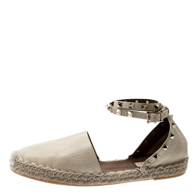 Step out in style with these trendy espadrilles from Valentino. The white flats feature closed toes, ankle wraps with pyramid studs, and braided detailing on the midsoles. These leather flats are sure to stand out every season.

Includes: Original